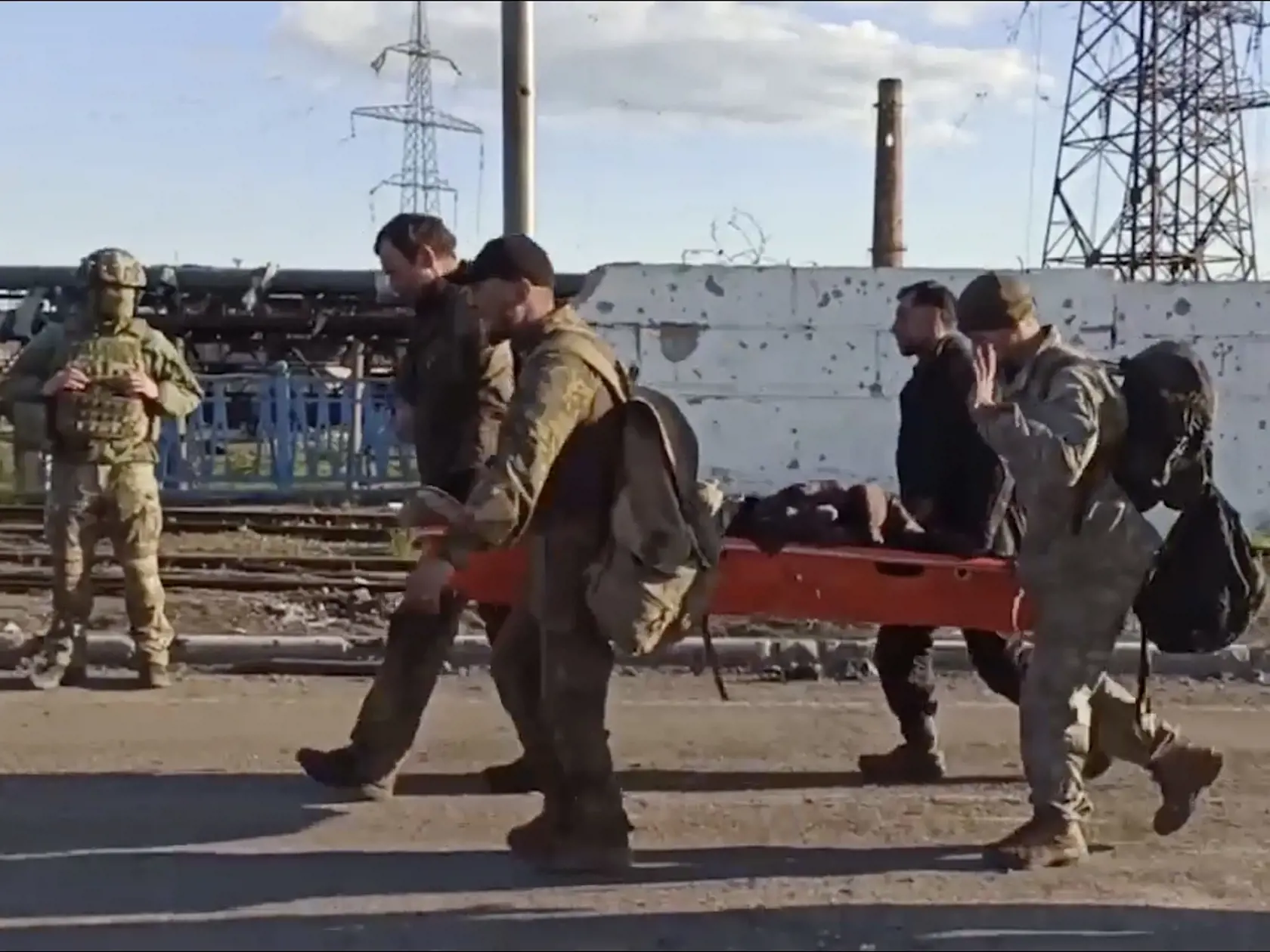 KK3 Mariupol - Na videosnímke ukrajinskí vojaci nesú zraneného spolubojovníka počas ich evakuácie z obliehanej oceliarne Azovstaľ v ukrajinskom Mariupole 17. mája 2022. Ruské ministerstvo obrany v utorok uviedlo, že viac než 250 ukrajinských bojovníkov, ktorí sa skrývali v oceliarňach Azovstaľ v meste Mariupol, sa vzdalo. FOTO TASR/AP
In this photo taken from video released by the Russian Defense Ministry Press Service on Tuesday, May 17, 2022, Ukrainian servicemen carry a wounded comrade as the