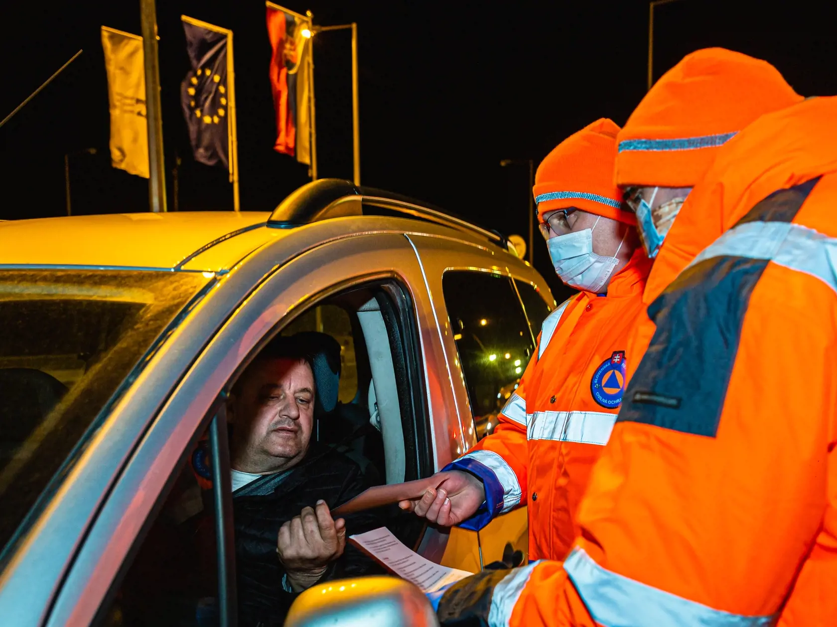 Dobrovoľníci civilnej ochrany rozdávajú informačné letáky ku koronavírusu na hraničnom priechode Jarovce medzi SR a Rakúskom. Väčšina vodičov reaguje pozitívne.