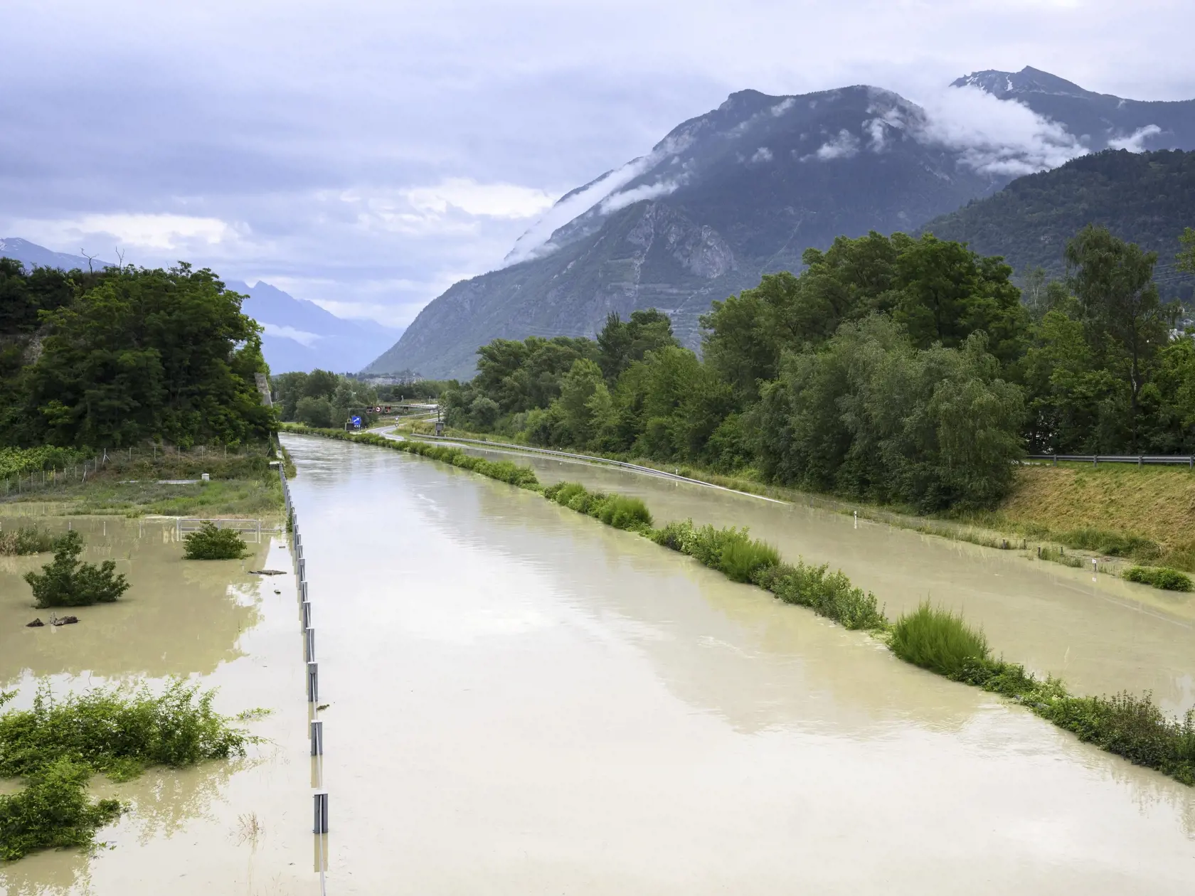Voda z rieky Rhône sa vyliala na diaľnicu A9 po silných búrkach, ktoré spôsobili záplavy v meste Sierre na juhozápade Švajčiarska v nedeľu 30. júna 2024. 

 The Rhone River is overflowing the A9 motorway following the storms that caused major flooding, in Sierre, Switzerland, Sunday, June 30, 2024. (Jean-Christophe Bott/Keystone via AP)