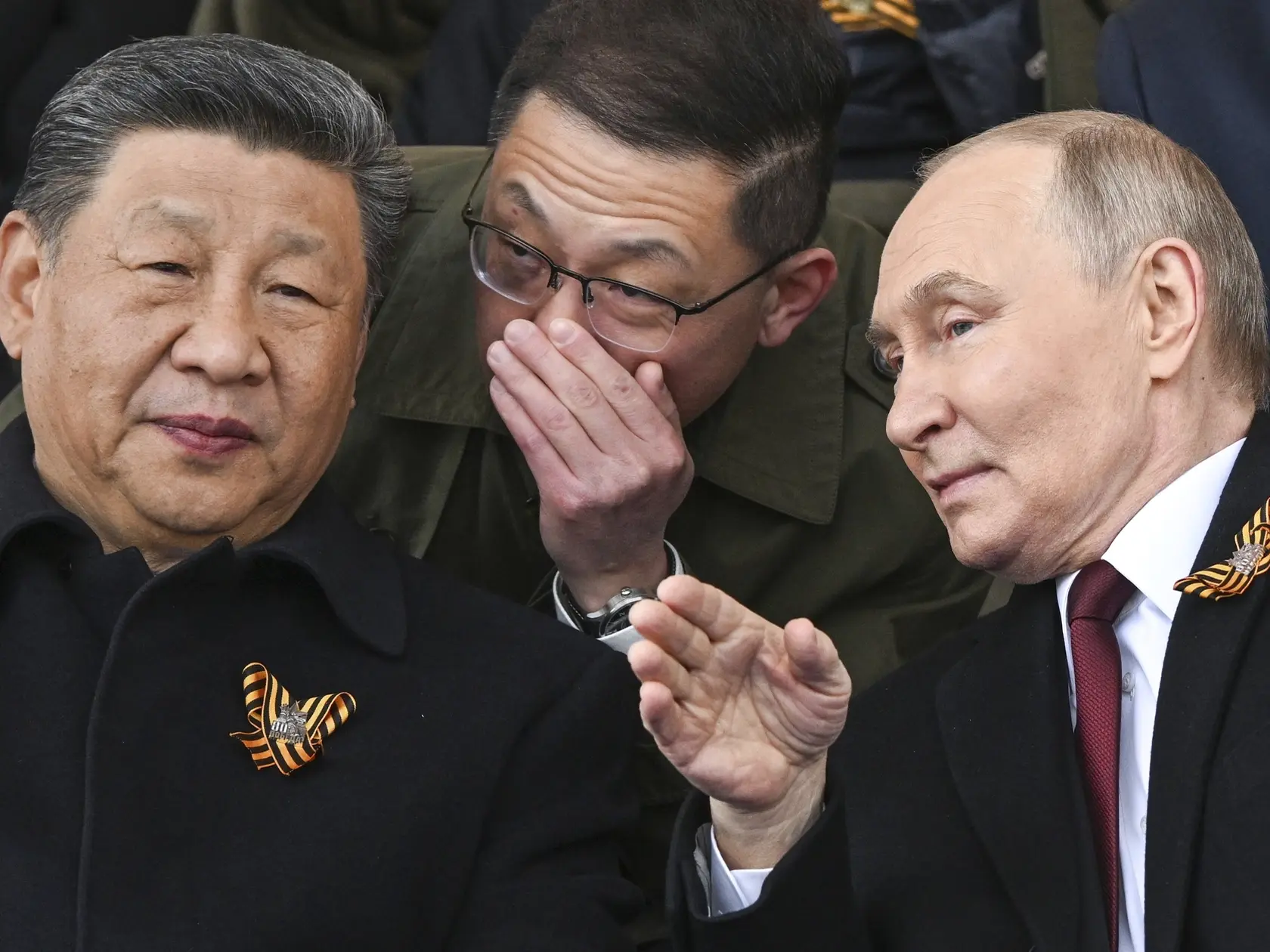Ruský prezident Vladimir Putin a čínsky prezident Si Ťin-pching sa rozprávajú počas sledovania vojenskej prehliadky pri príležitosti 80. výročia konca druhej svetovej vojny v Európe v Moskve 9. mája 2025.