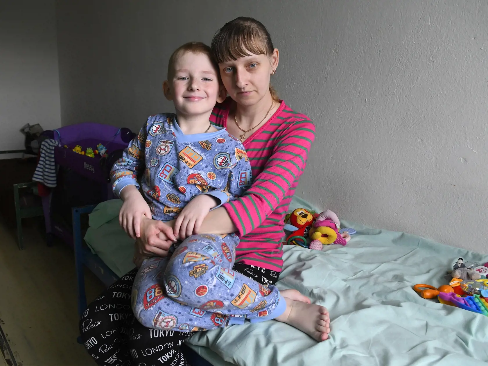 Celkovo 131 utečencov z Ukrajiny je aktuálne ubytovaných v Otvorenom oddelení Ústavu na výkon väzby (ÚVV) a Ústavu na výkon trestu odňatia slobody (ÚVTOS) na prešovskom sídlisku Šváby. Kapacita zariadenia je 151 ľudí, donedávna tam bolo 54 odsúdených, ktorých premiestnili na oddelenie v Sabinove. Na snímke Xénia Djačenková z Doneckej oblasti z Ukrajiny zo sedemročným synom Žeňom, v pozadí v postieľke spí sedemmesačná dcérka Táňa. Prešov, 5. apríla 2022. FOTO TASR – Milan Kapusta
