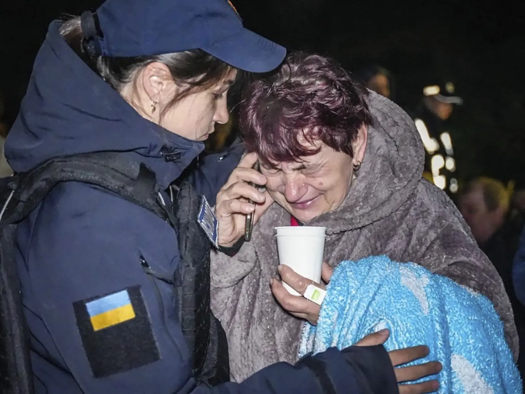 Psychologička pohotovostnej služby (vľavo) utešuje ženu na mieste zničenej budovy po ruskom raketovom útoku v ukrajinskej Odese 23. apríla 2024.