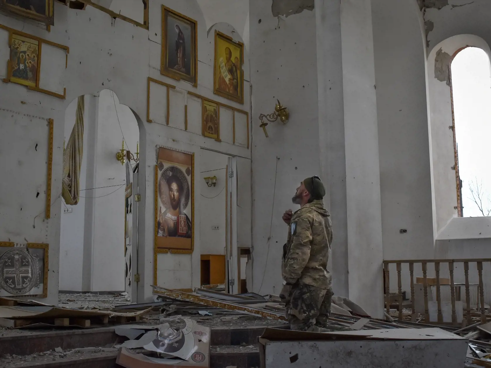 Ukrajinský vojak kľačí a modlí sa v kostole zničenom po leteckom útoku ruskej armády v meste Orichiv, ktoré sa nachádza na frontovej línii v ukrajinskej Záporožskej oblasti v piatok 5. apríla 2024.