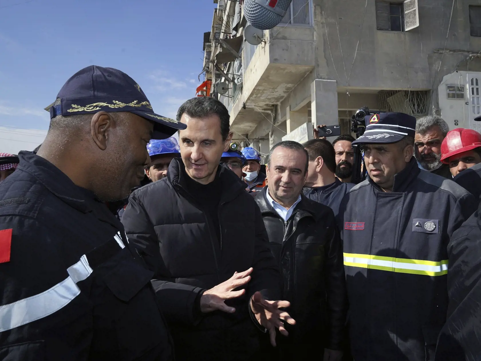 KK25 Aleppo - Sýrsky prezident Bašár Asad (druhý vľavo) sa rozpráva s alžírskym záchranným tímom na mieste zničenách budov po zemetrasení v meste Aleppo 10. februára 2023. Sýrsky prezident Bašár Asad v piatok prvýkrát navštívil sever Sýrie, ktorý v pondelok zasiahlo mohutné zemetrasenie s epicentrom v susednom Turecku. Podľa záberov, ktoré zverejnila prezidentská kancelária, Asad navštívil aj oblasti mesta zničené zemetrasením s magnitúdou 7,8. V dôsledku tohto zemetrasenia, ktoré sa radí k najv
