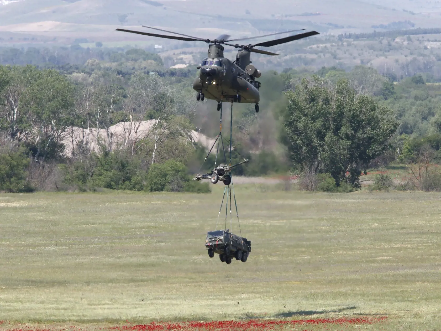 PK 9 Krivolak - Britský vrtuľník Chinook prepravuje húfnicu a vojenské nákladné vozidlo počas vojenských cvičení NATO Swift Response 22 (Rýchla odozva) ponad armádnym výcvikovým areálom Krivolak v centrálnej časti Severného Macedónska vo štvrtok 12. mája 2022. Cvičenia sú zamerané na preukázanie pripravenosti nasadenia pozdĺž východnej hranice NATO a zahŕňajú napríklad zoskoky s padákom na rôznych miestach krajiny. Na manévroch sa zúčastňuje zhruba 10.000 vojakov z 19 krajín. FOTO TASR/AP

A Bri