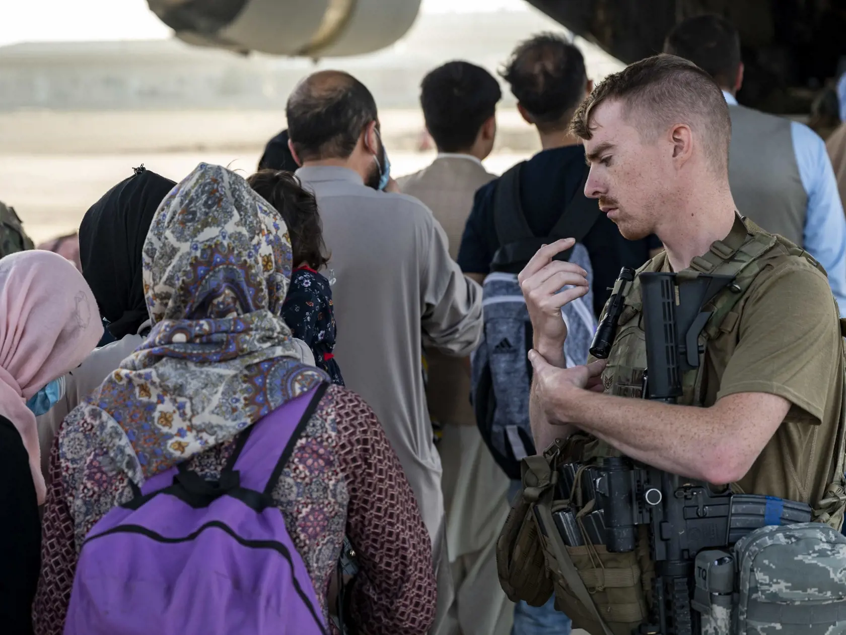 JB 36 Kábul - Na snímke amerických námorných síl  americký vojak asistuje Afgancom, ktorí nastupujú do lietadla amerických vzdušných síl Boeing C-17 Globemaster III počas evakuácie na medzinárodnom letisku Hamída Karzaja v Kábule 25. augusta 2021. Na letisku v Kábule v súčasnosti prebieha chaotická evakuácia po tom, ako militantné hnutie Taliban obsadilo Afganistan. Americký prezident Joe Biden dodrží sťahovanie vojakov USA do budúceho utorka 31. augusta napriek tomu, že tisíce Afgancov stále dú