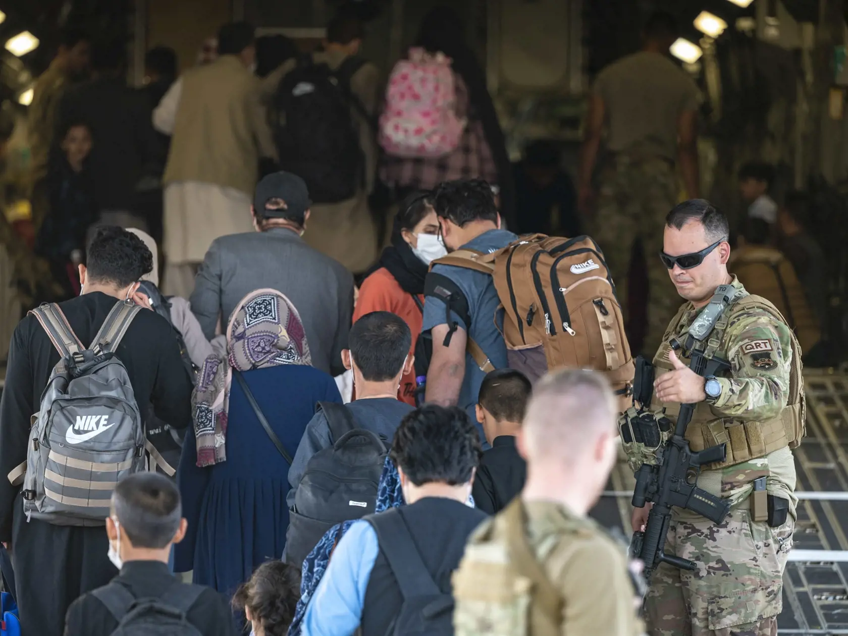JB 38 Kábul - Na snímke amerických námorných síl  americký vojak asistuje Afgancom, ktorí nastupujú do lietadla amerických vzdušných síl Boeing C-17 Globemaster III počas evakuácie na medzinárodnom letisku Hamída Karzaja v Kábule 25. augusta 2021. Na letisku v Kábule v súčasnosti prebieha chaotická evakuácia po tom, ako militantné hnutie Taliban obsadilo Afganistan. Americký prezident Joe Biden dodrží sťahovanie vojakov USA do budúceho utorka 31. augusta napriek tomu, že tisíce Afgancov stále dú