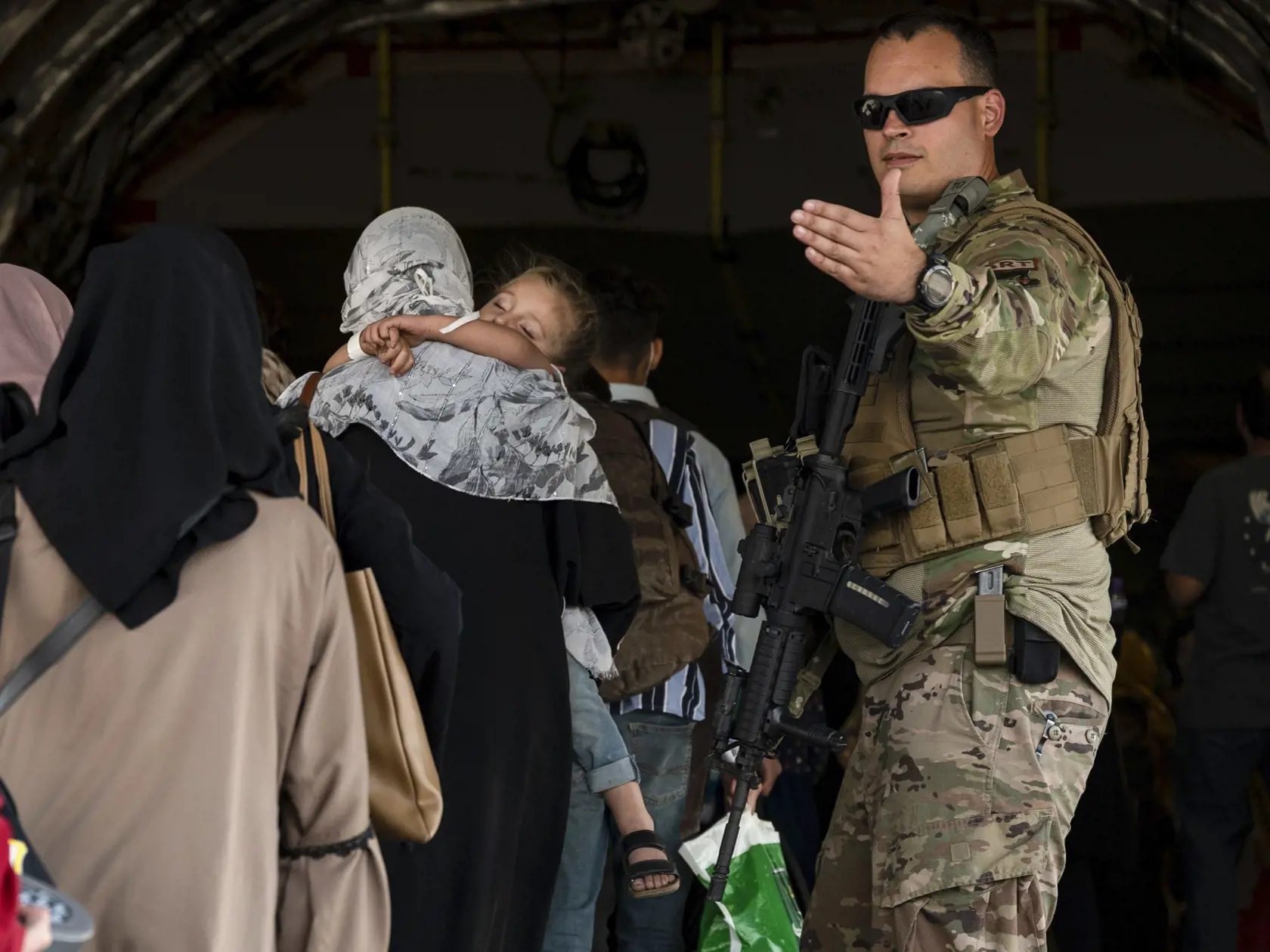 JB 37 Kábul - Na snímke amerických námorných síl  americký vojak asistuje Afgancom, ktorí nastupujú do lietadla amerických vzdušných síl Boeing C-17 Globemaster III počas evakuácie na medzinárodnom letisku Hamída Karzaja v Kábule 25. augusta 2021. Na letisku v Kábule v súčasnosti prebieha chaotická evakuácia po tom, ako militantné hnutie Taliban obsadilo Afganistan. Americký prezident Joe Biden dodrží sťahovanie vojakov USA do budúceho utorka 31. augusta napriek tomu, že tisíce Afgancov stále dú