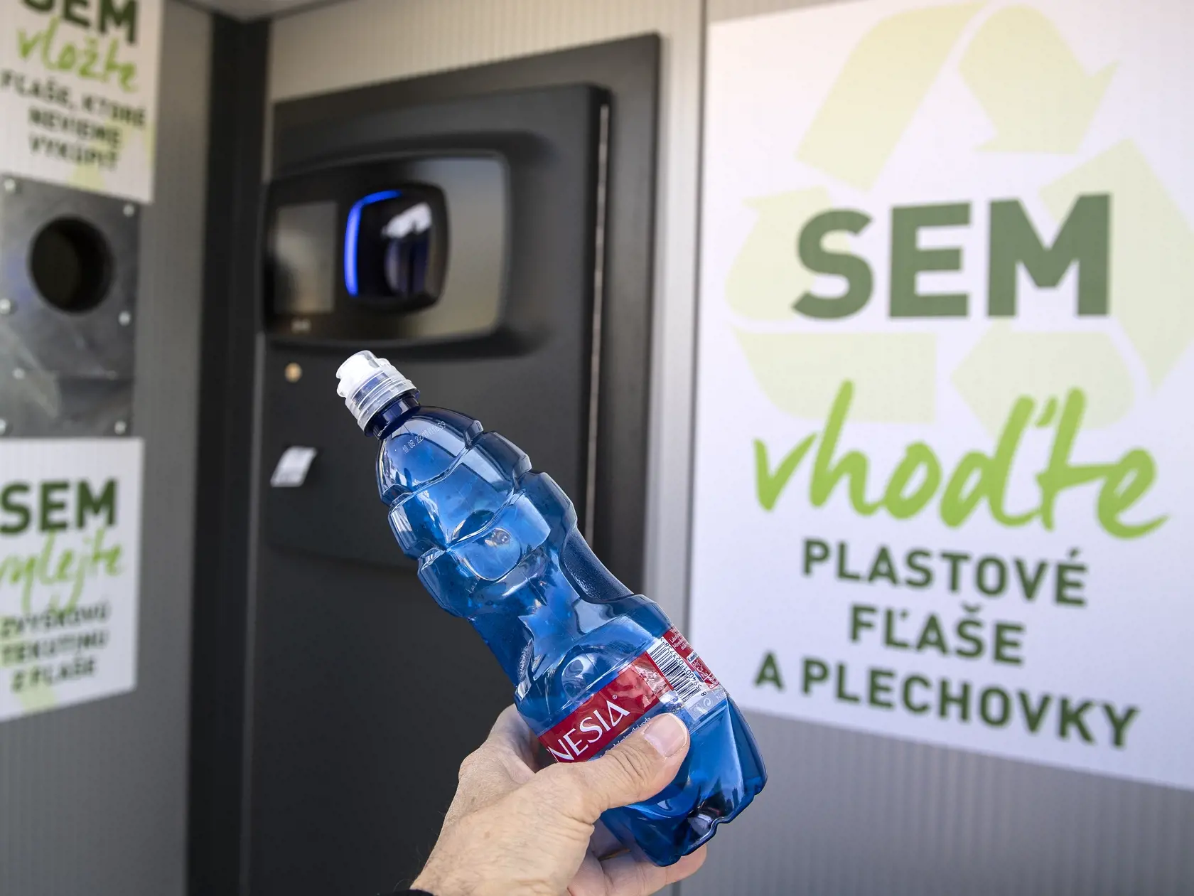 Na snímke vhadzovanie PET fliaš do kontajneru na začiatku testovacej fázy zálohovania PET fliaš a plechoviek na parkovisku na Bajkalskej ulici 14. októbra 2021 v Bratislave. FOTO TASR - Pavel Neubauer	
