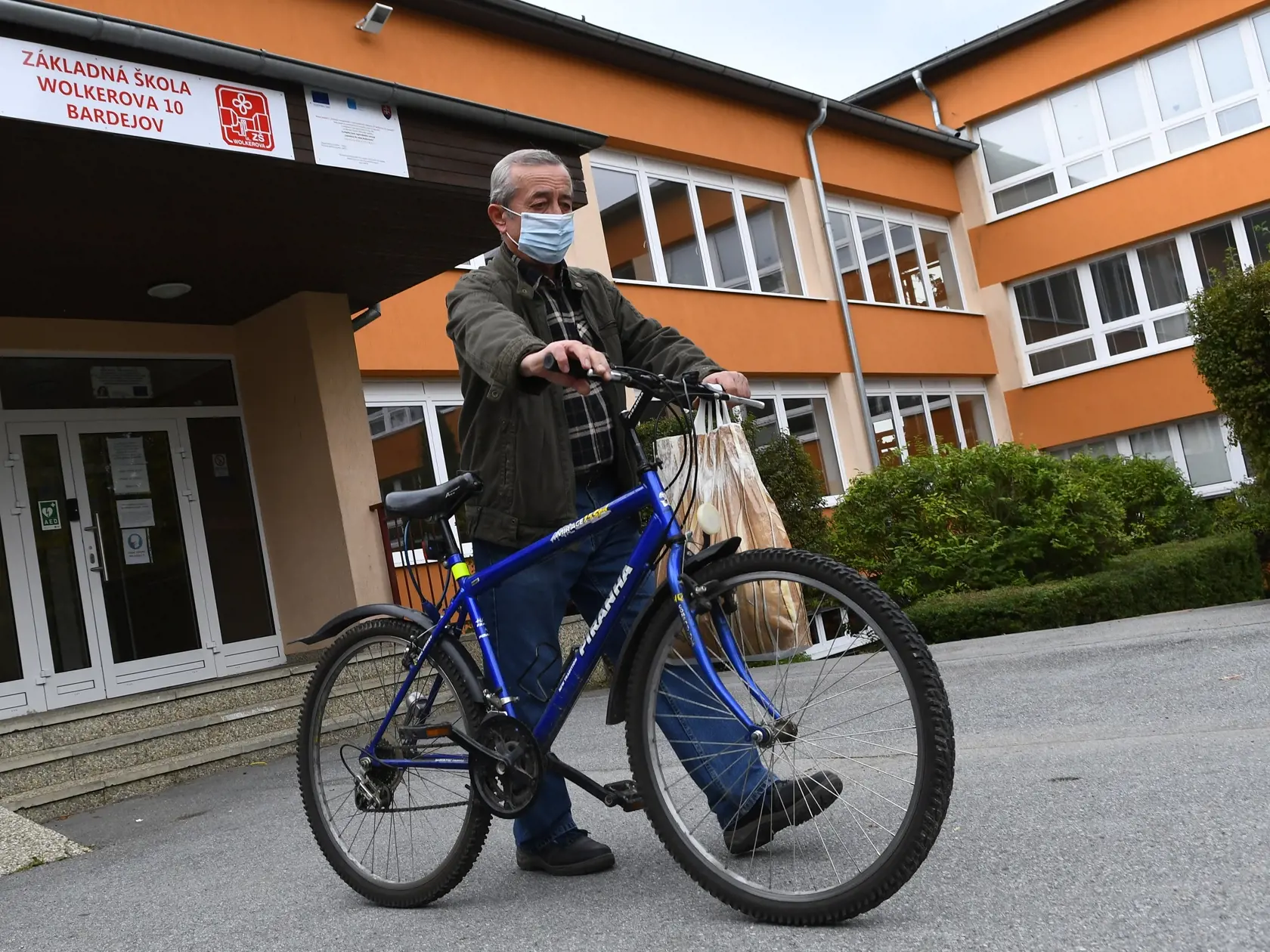 Mesto Bardejov kvôli druhej vlne pandémie nového koronavírusu od pondelka zatvorilo základné školy vo svojej zriaďovateľskej pôsobnosti. Rozhodol o tom v piatok mestský krízový štáb (MKŠ) na svojom mimoriadnom večernom rokovaní. Na snímke školník Stanislav Lenárt odchádza po tom čo uzamkol vchod do ZŠ Wolkerova 10 v Bardejove 5. októbra 2020. FOTO TASR - Milan Kapusta


