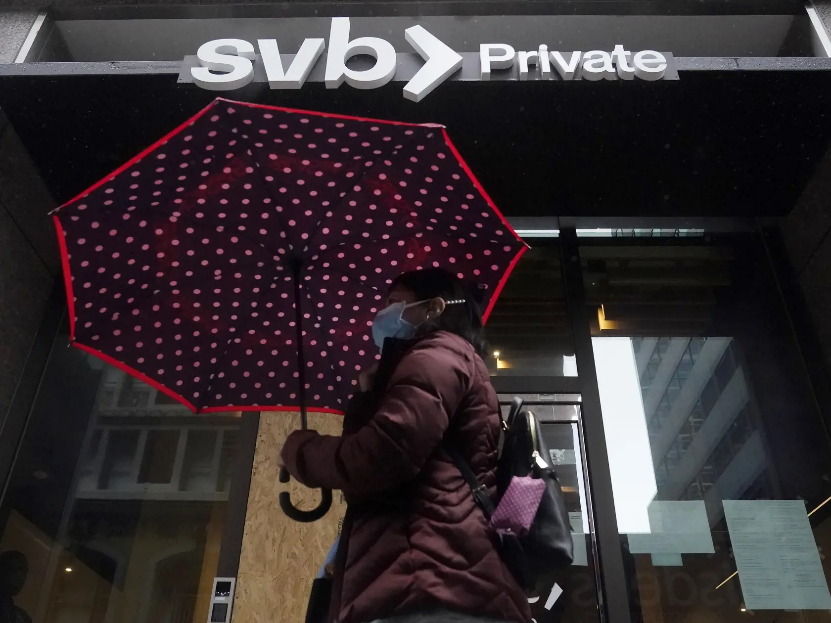 KK51 San Francisco - Žena s dáždnikom kráča okolo pobočky banky Silicon Valley Bank 14. marca 2023 v San Franciscu. Americké úrady preverujú kolaps Silicon Valley Bank (SVB) pre pochybenia jej predstaviteľov vrátane toho, či pri predaji akcií jej vedúci pracovníci porušili pravidlá obchodovania. FOTO TASR/AP
A pedestrian carries an umbrella while walking past a Silicon Valley Bank Private branch in San Francisco, Tuesday, March 14, 2023. After a frenetic weekend of round-the-clock briefings, U.S