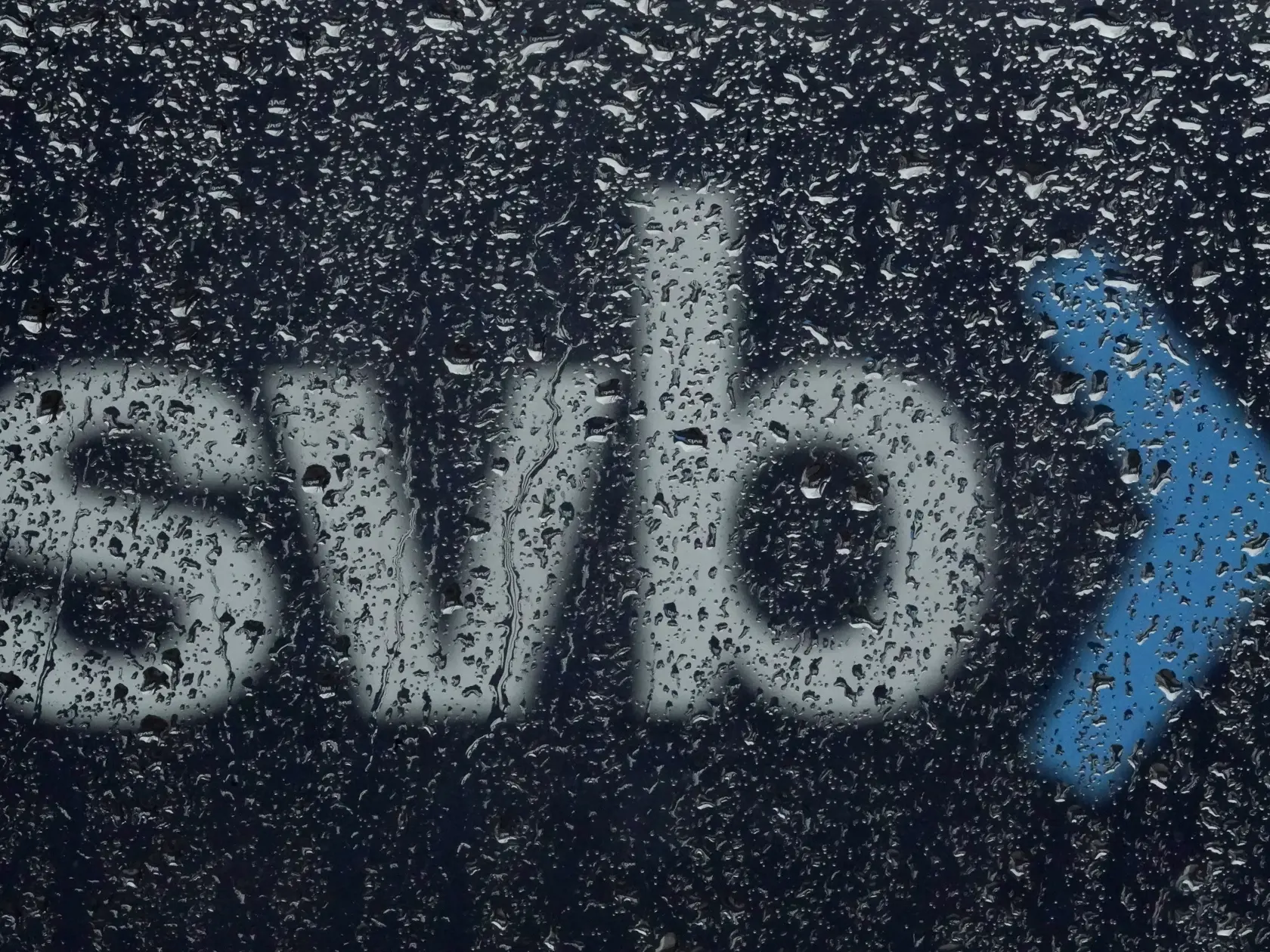 KK36 Santa Clara - Na snímke pohľad cez dažďové kvapky na nápis banky Silicon Valley Bank 10. marca 2023 v Santa Clare.  Americké úrady v piatok zatvorili Silicon Valley Bank (SVB), aby ochránili vkladateľov. V pondelok (13. 3.) sa jej pobočky znovu otvoria, ale pod kontrolou federálneho úradu na ochranu vkladov (FDIC). FOTO TASR/AP
A sign to Silicon Valley Bank is seen through raindrops on a window in Santa Clara, Calif., Friday, March 10, 2023.  The Federal Deposit Insurance Corporation is sei