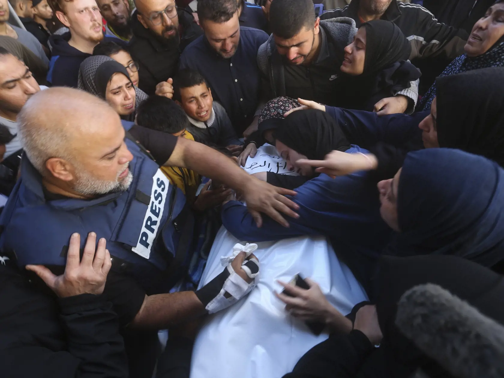 WA 43 Rafah - Šéf kancelárie panarabskej televízie al-Džazíry v Pásme Gazy Wael Dahdúh (vľavo) stojí pri rakve svojho syna, ktorý prišiel o život pri izraelskom nálete v Pásme Gazy v Rafafu v nedeľu 7. januára 2024. Aj jeho syn Hamza Wael Dahdúh pracoval ako novinár pre al-Džazíru. Wael Dahdúh stratil manželku, ďalšie dve deti a vnuka, ktorí zahynuli pri izraelskom útoku počas prvých týždňov vojny. Nedávno tiež utrpel pri útoku zranenia. FOTO TASR/AP  


Al Jazeera journalist Wael Dahdouh mourns
