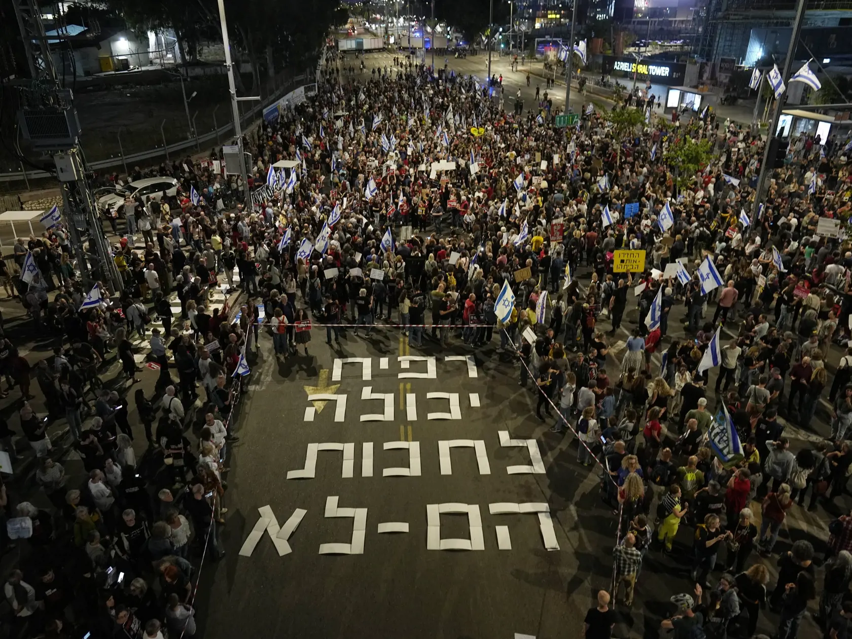 WA 14 Tel Aviv - Ľudia sa zhromažďujú pri nápise v hebrejčine Rafah môže počkať, oni nie počas protestu v Tel Avive v pondelok 29. apríla 2024. Odkazuje na možnú izraelskú pozemnú ofenzívu na mesto Rafah na juhu Pásma Gazy a vyzýva na prepustenie izraelských rukojemníkov zadržiavaných plaestínskym militantným hnutím Hamas. FOTO TASR/AP  

People gather next to a sign displayed on the street that reads in Hebrew "Rafah can wait, they cannot", in reference of a possible Israeli offensive on the Ra