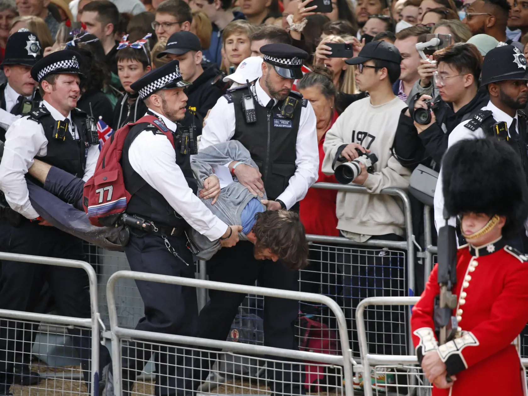 WA 50 Londýn - Policajti zadržali muža, ktorý narušil slávnostnú vojenskú prehliadku (Trooping the Color), ktorou sa začali štvordňové oslavy 70. výročia nástupu britskej kráľovnej Alžbety II. na trón v Londýne vo štvrtok 2. júna 2022. Kráľovná Alžbeta II. (96) oslávila 70 rokov na tróne vo februári a celonárodné oslavy jej platinového jubilea, vrátane ďakovnej bohoslužby a hudobného koncertu pred Buckinghamským palácom, sa budú konať od 2. do 5. júna. FOTO TASR/AP
   
Police officers remove a m