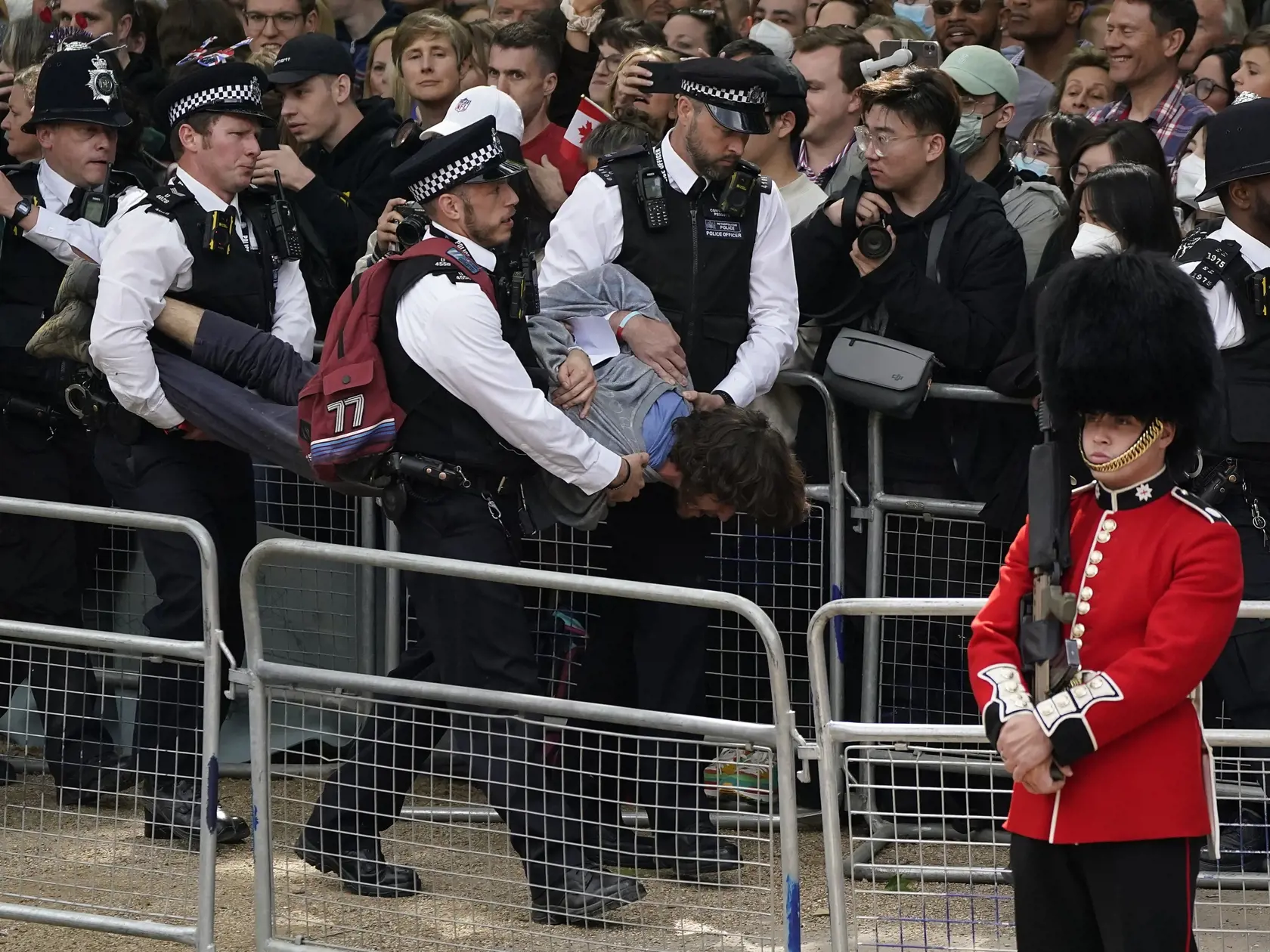 WA 53 Londýn - Policajti zadržali muža, ktorý narušil slávnostnú vojenskú prehliadku (Trooping the Color), ktorou sa začali štvordňové oslavy 70. výročia nástupu britskej kráľovnej Alžbety II. na trón v Londýne vo štvrtok 2. júna 2022. Kráľovná Alžbeta II. (96) oslávila 70 rokov na tróne vo februári a celonárodné oslavy jej platinového jubilea, vrátane ďakovnej bohoslužby a hudobného koncertu pred Buckinghamským palácom, sa budú konať od 2. do 5. júna. FOTO TASR/AP
   
Police officers remove a m