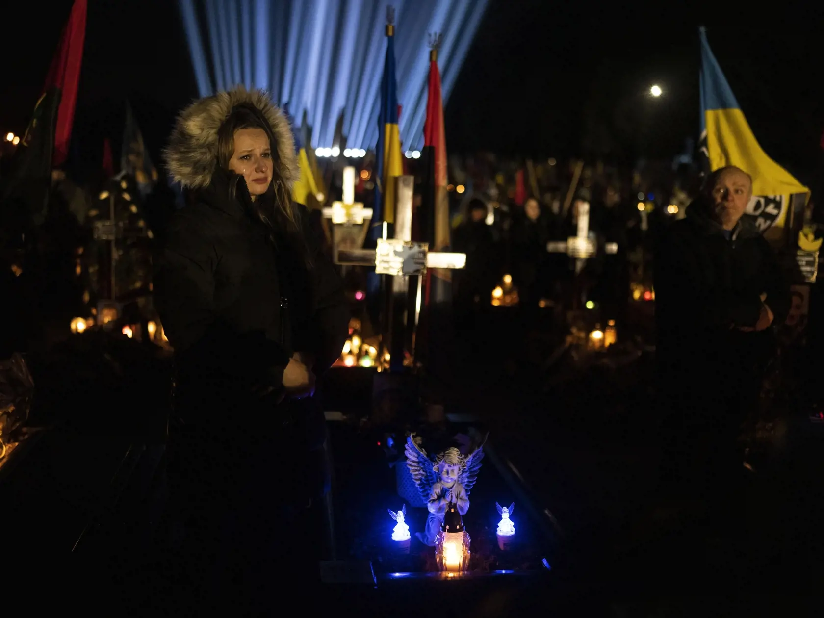 Na snímke 35-ročná Julija plače pri hrobe svojho manžela na cintoríne v Ľvove vo štvrtok 23. februára 2023. Rodinní príslušníci sa zišli na vojenskom cintoríne v Ľvove, aby si uctili pamiatku tých, ktorí zahynuli v boji proti ruskej invázii na Ukrajine.