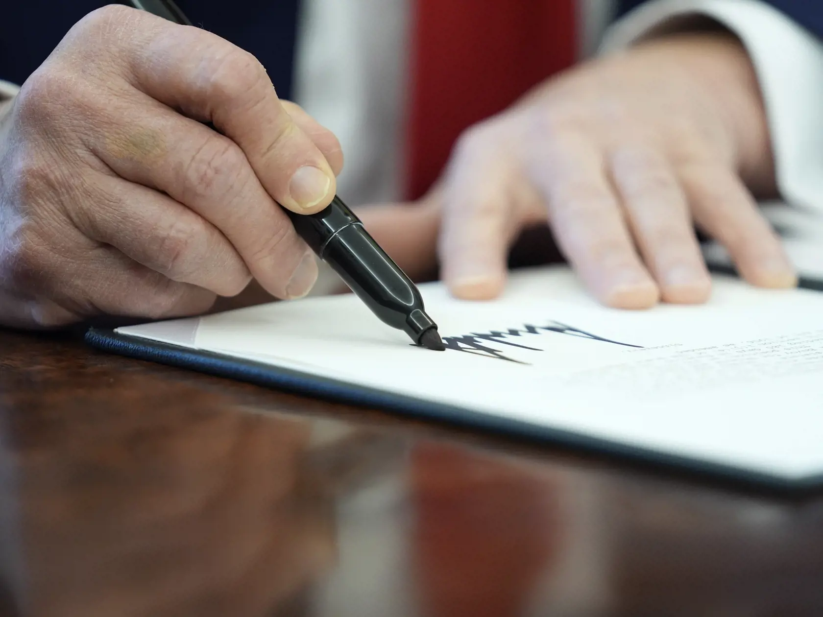Prezident USA Donald Trump podpisuje výkonné nariadenie v Oválnej pracovni Bieleho domu vo Washingtone 3. februára 2025.