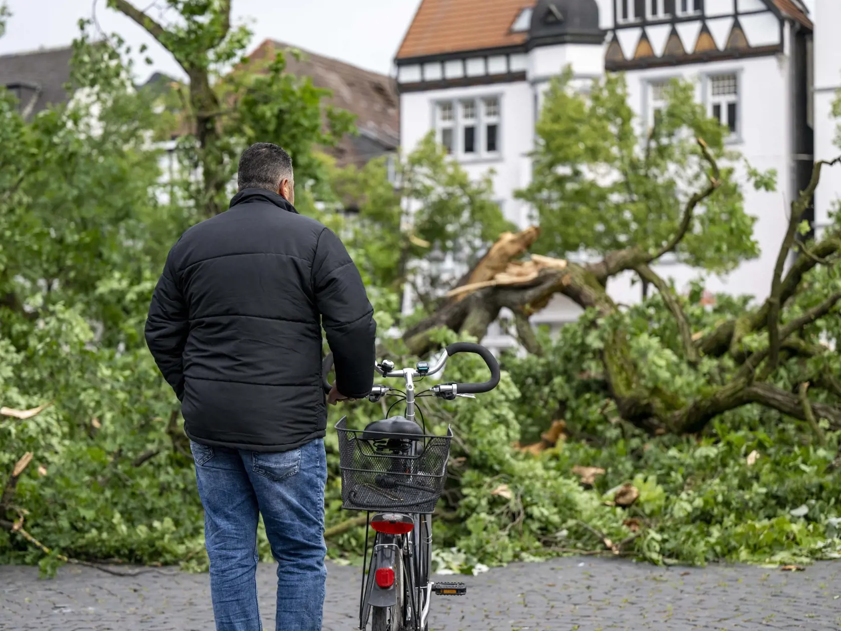 Muž stojí pred vyvráteným stromom na námestí v nemeckom meste Lippstadt.