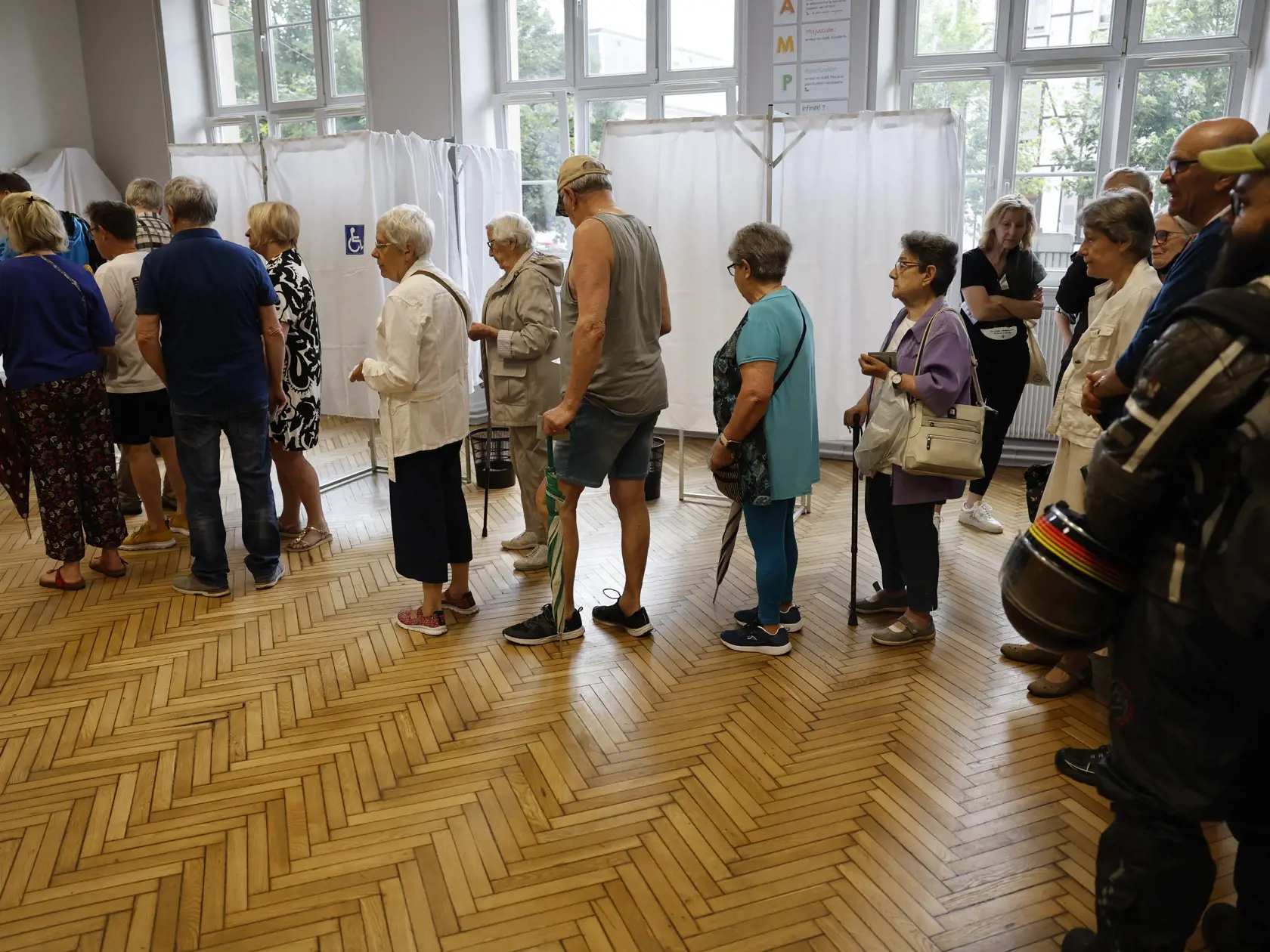 Voliči čakajú v rade vo volebnej miestnosti v Štrasburgu počas 1. kola predčasných parlamentných volieb vo Francúzsku v nedeľu 30. júna 2024. Predčasné voľby vyhlásil prezident Emmanuel Macron v reakcii na výsledky eurovolieb. Druhé kolo bude 7. júla.