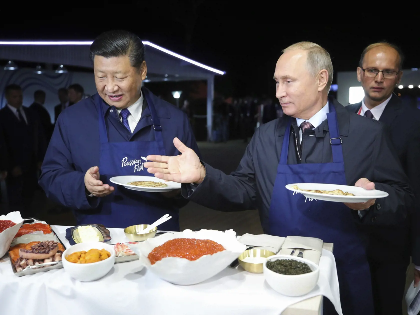 Na snímke čínsky prezident Si Ťin-pching (vľavo) a ruský prezident Vladimir Putin spoločne ochutnávajú ruské rybie špeciality na výstave počas Východného ekonomického fóra v ruskom Vladivostoku 11. septembra 2018.