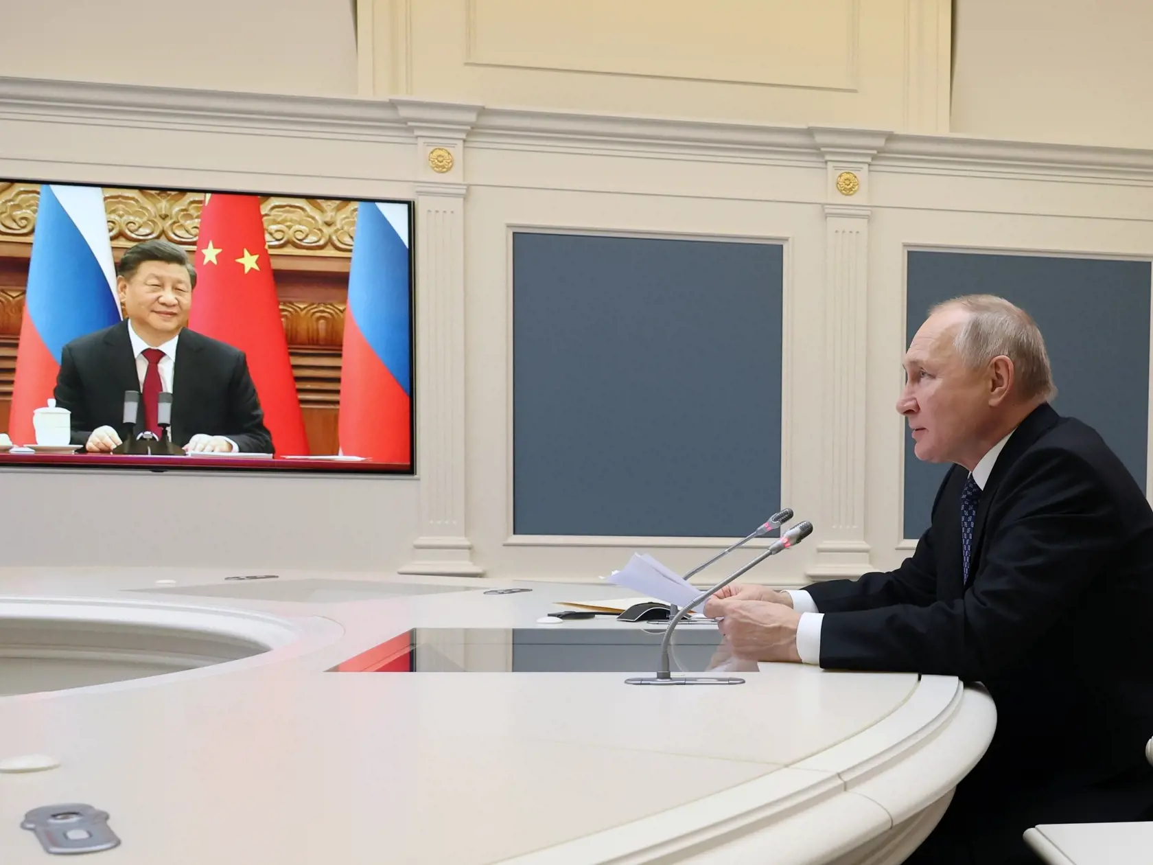 Ruský prezident Vladimir Putin (vpravo), ktorý rokuje s čínskym prezidentom Si Ťin-pchingom (na obrazovke vľavo) prostredníctvom videospojenia v Moskve v piatok 30. decembra 2022.