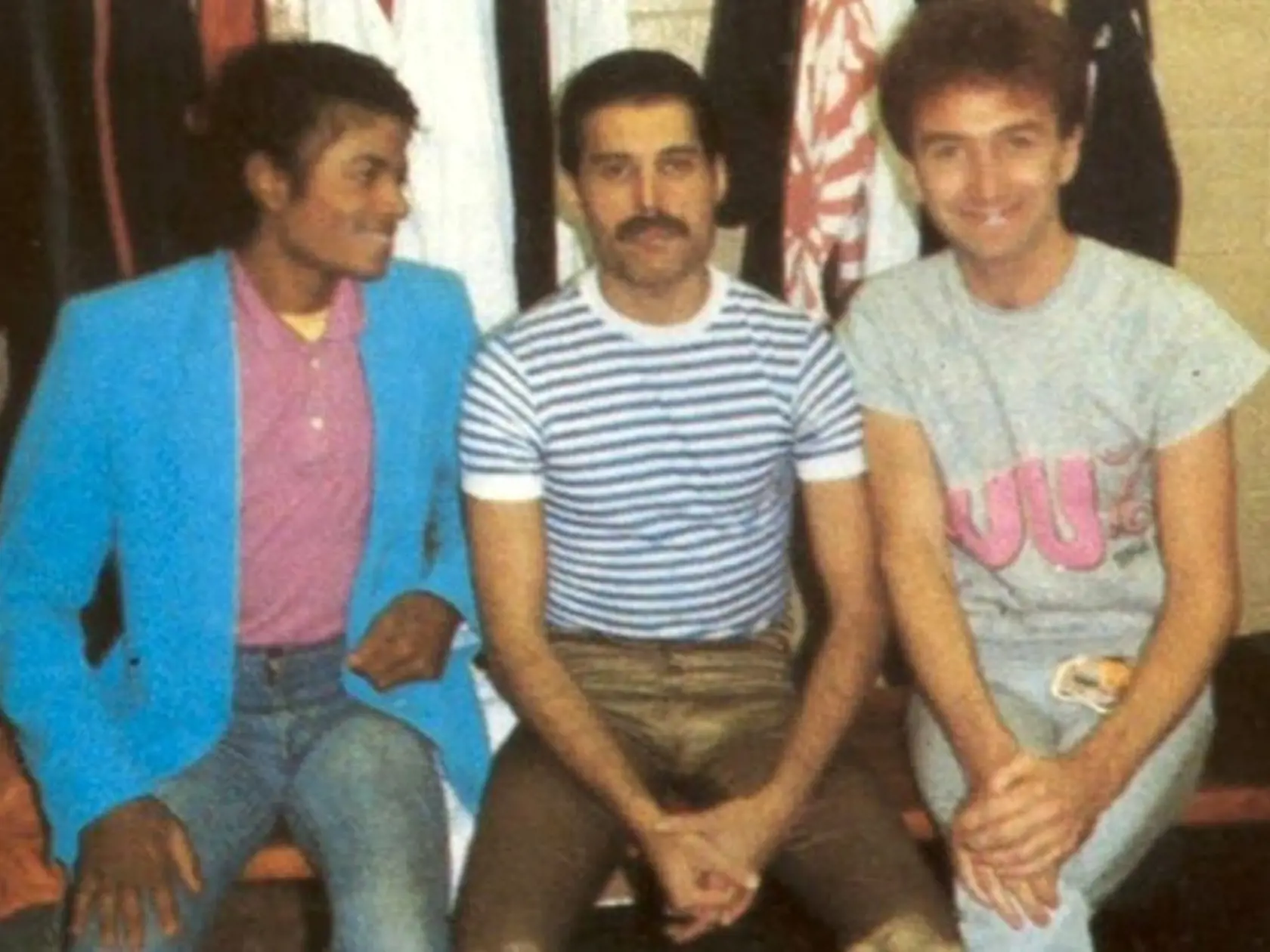 Spevák Queen Freddie Mercury, v strede, kráľ popu Michael Jackson, vľavo, a basgitarista Queen John Deacon.