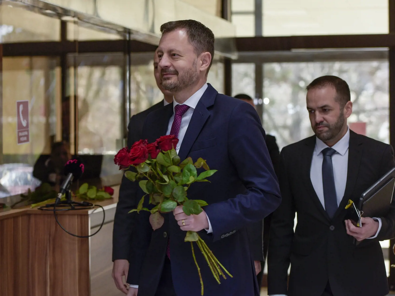 Na snímke dočasne poverený predseda vlády SR Eduard Heger prichádza s červenými ružami pri príležitosti Medzinárodného sviatku žien (MDŽ) na 139. rokovanie vlády SR v Bratislave v stredu 8. marca 2023. FOTO TASR - Pavol Zachar