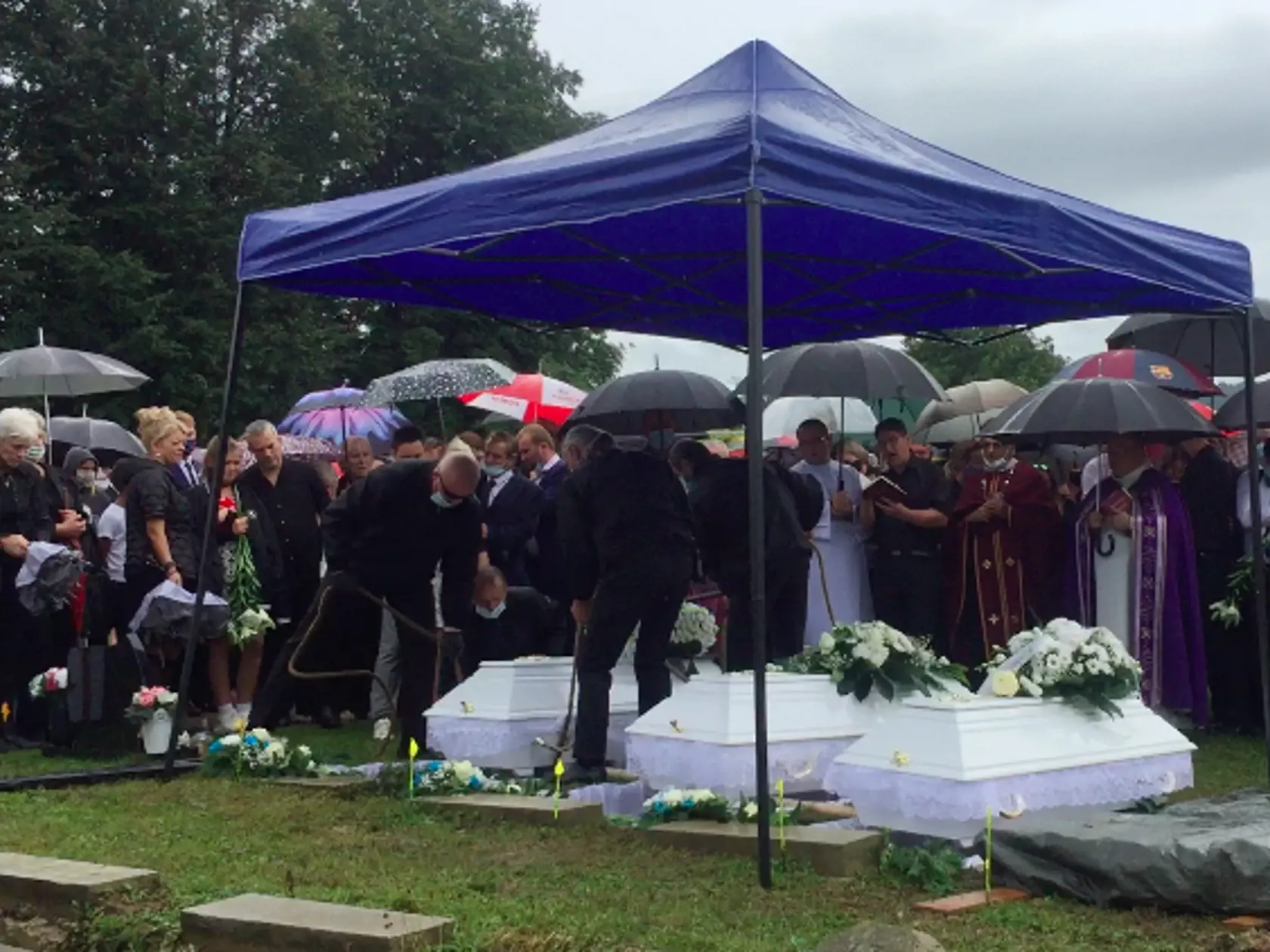 Tri biele truhličky uložili do zeme vedľa seba.