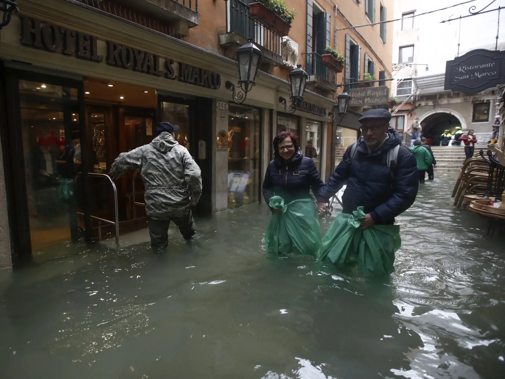 EBE 30 Benátky - Na snímke ľudia sa brodia v zaplavených uliciach v Benátkach 15. novebra 2019. FOTO TASR/AP
People wade their way through water in Venice, Italy, Friday, Nov. 15, 2019. Waters are rising in Venice where the tide is reaching exceptional levels just three days after the Italian lagoon city experienced its worst flooding in more than 50 years. (AP Photo/Luca Bruno)