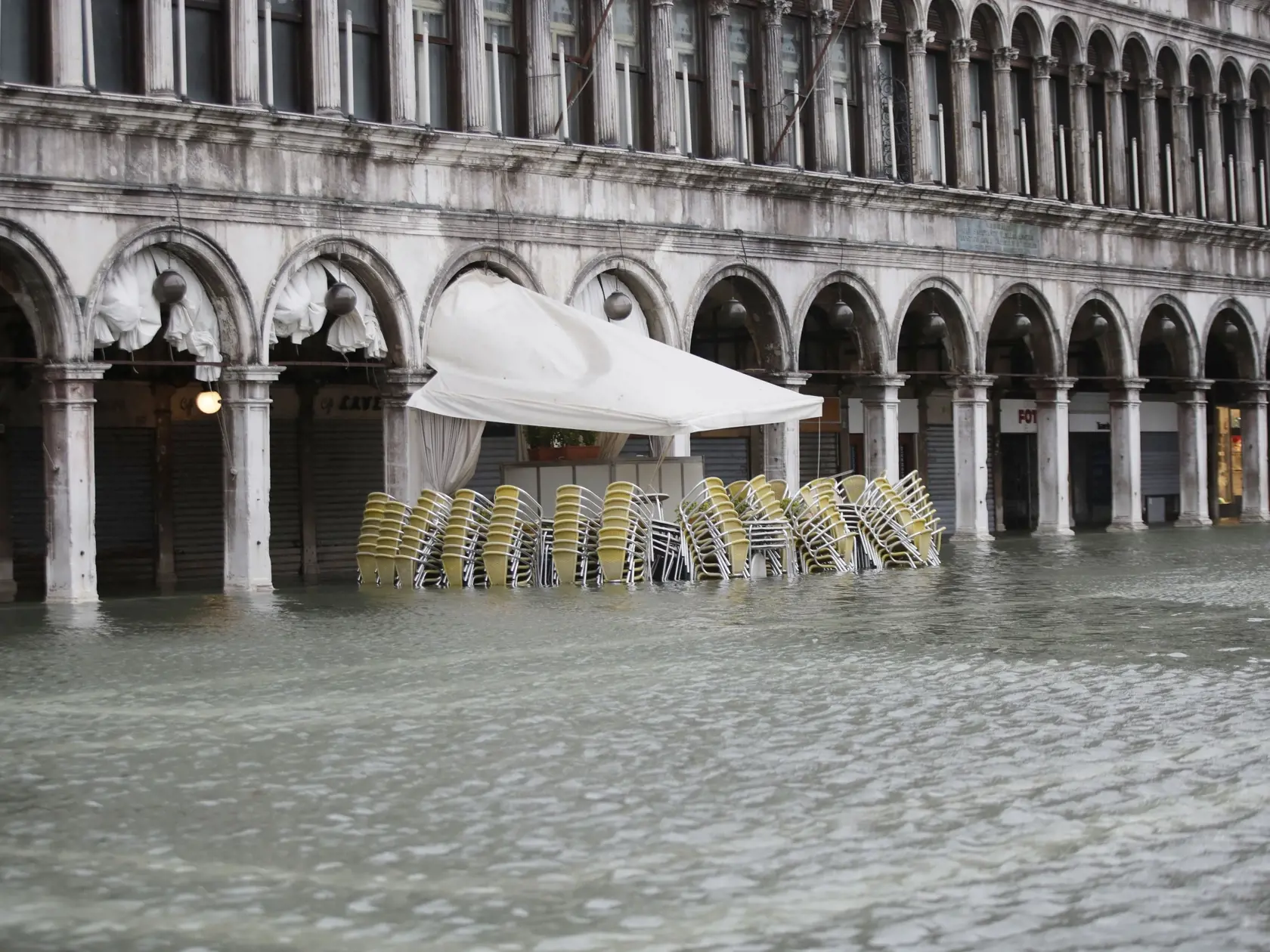EBE 20 Benátky - Na snímke stoličky a stoly pred zavretým barom na zaplavenom Námestí sv. Marka v Benátkach 15. novebra 2019. FOTO TASR/AP
Chairs and tables are piled up outside a closed bar in a flooded St. Mark's Square at Venice, Italy, Friday, Nov. 15, 2019.The high-water mark hit 187 centimeters (74 inches) late Tuesday, Nov. 12, 2019, meaning more than 85% of the city was flooded. The highest level ever recorded was 194 centimeters (76 inches) during infamous flooding in 1966. (AP Photo/Lu