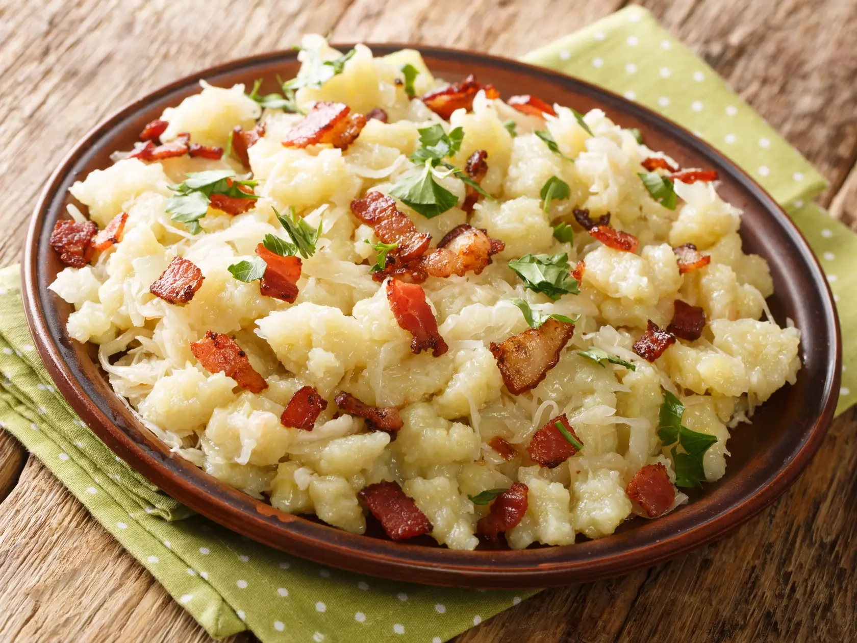 Potatoes, Bacon and Sauerkraut is Strapacky halusky closeup in the plate on the table. horizontal