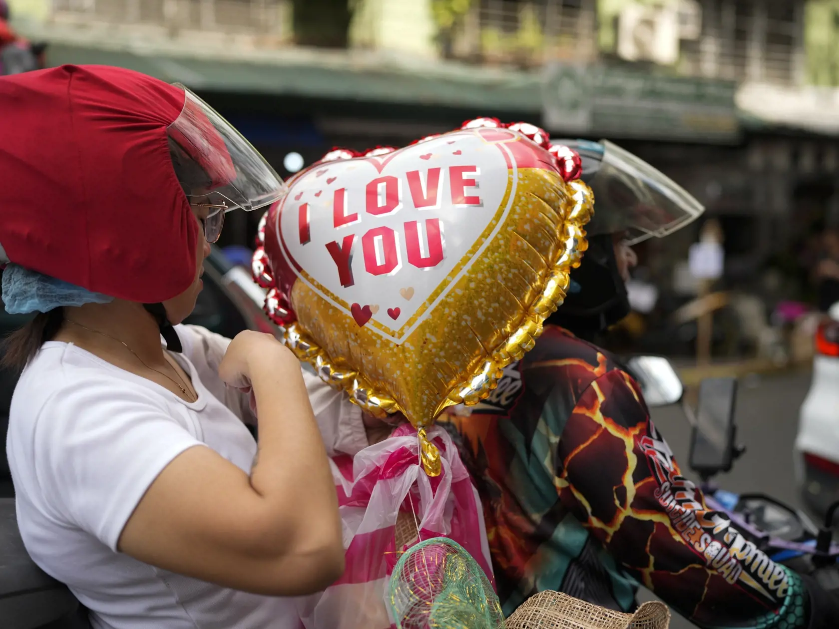 KK29 Manila - Žena drží balón počas jazdy na motorke na Deň sv. Valentína v Manile 14. februára 2024. FOTO TASR/AP
A woman holds a balloon as she rides a motorcycle on Valentineâ€™s Day on Wednesday, Feb. 14, 2024, in Manila, Philippines. (AP Photo/Aaron Favila)