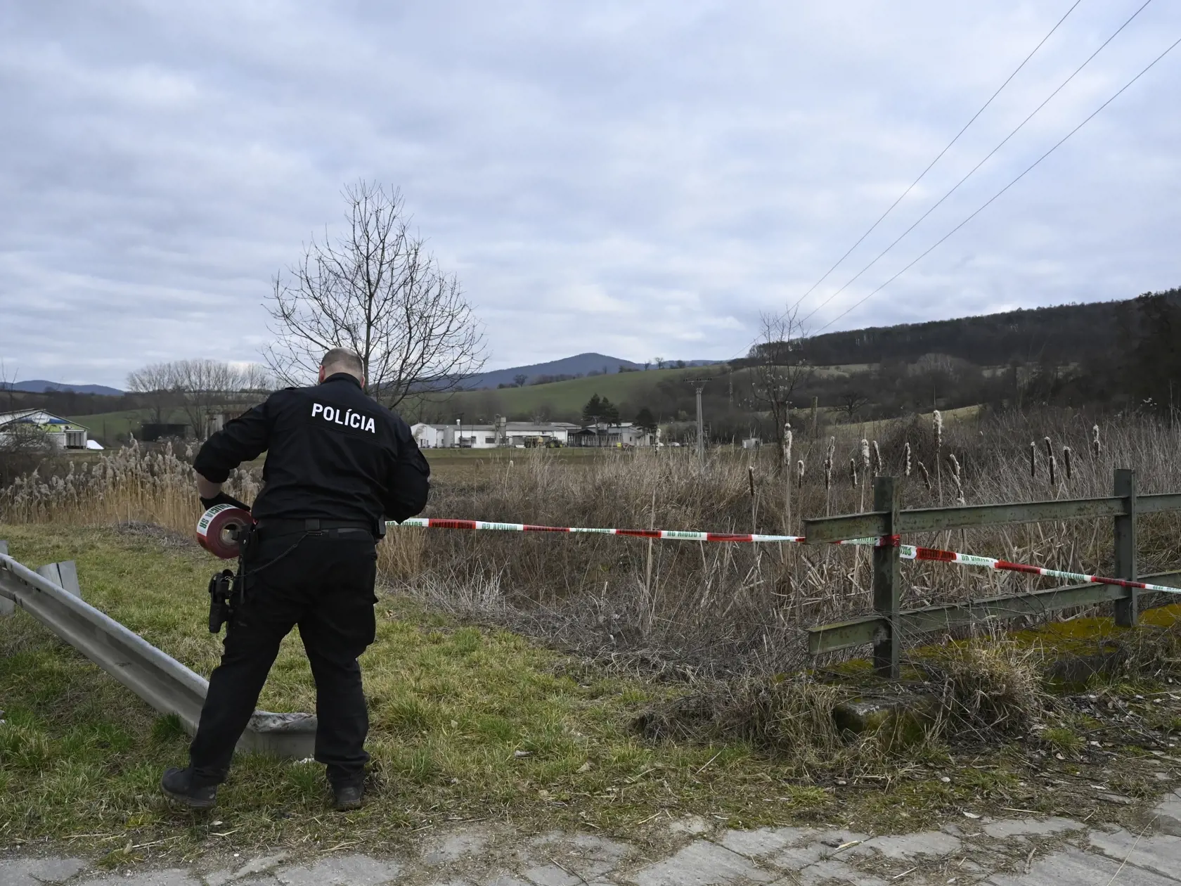 Pri obci Trenčianske Stankovce v okrese Trenčín havarovalo v stredu 22. februára 2023 motorové lietadlo, nehodu neprežili štyria ľudia. Na snímke policajt ohradzuje policajnou páskou miesto nehody. FOTO TASR - Radovan Stoklasa 