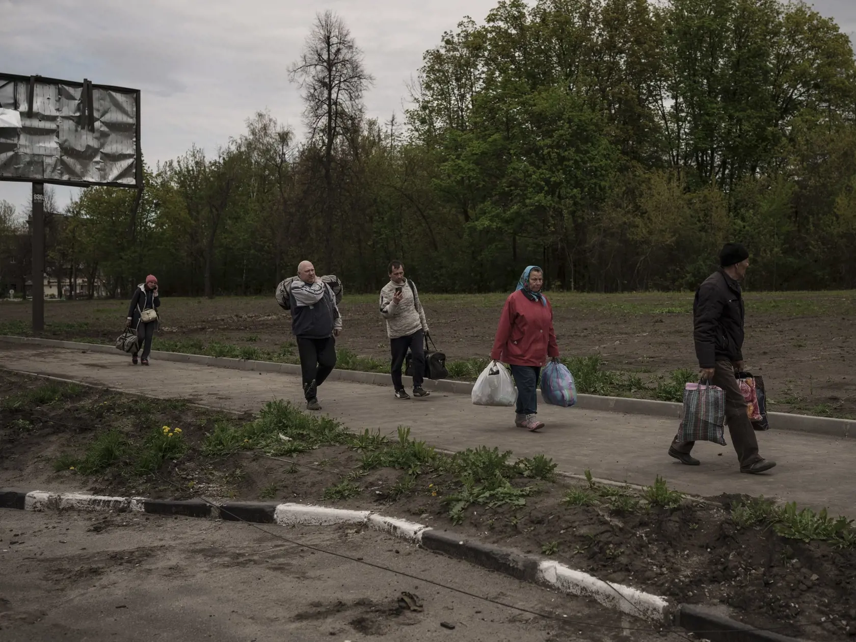 WA 41 Charkov - Ľudia z neďalekej dediny Ruská Lozova, ktorú po vyše mesiaci ruskej okupácie oslobodili ukrajinské sily, prichádzajú na kontrolné stanovište do Charkova počas 65. dňa ruskej invázie na Ukrajinu v piatok 29. apríla 2022. Takmer polovica obyvateľov dediny utiekla na autobusoch, poškodených autách či pešo po tom, čo odtiaľ ukrajinské sily v prudkých bojoch úplne vytlačili ruských vojakov, uviedol gubernátor Charkovskej oblasti Oleh Synehubov. FOTO TASR/AP 

People fleeing the villag