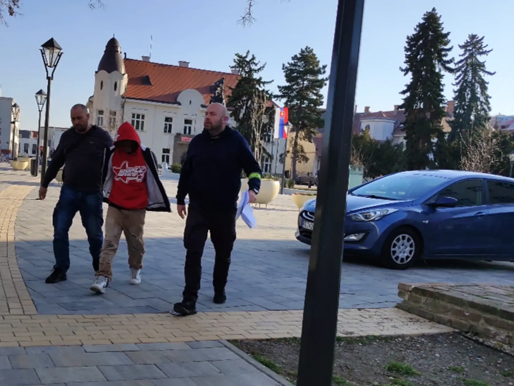 Policajná eskorta privádza na súd v Trnave 15-ročného mladíka, ktorý mal v Piešťanoch dobiť 18-ročného Tomáša teleskopickou palicou.