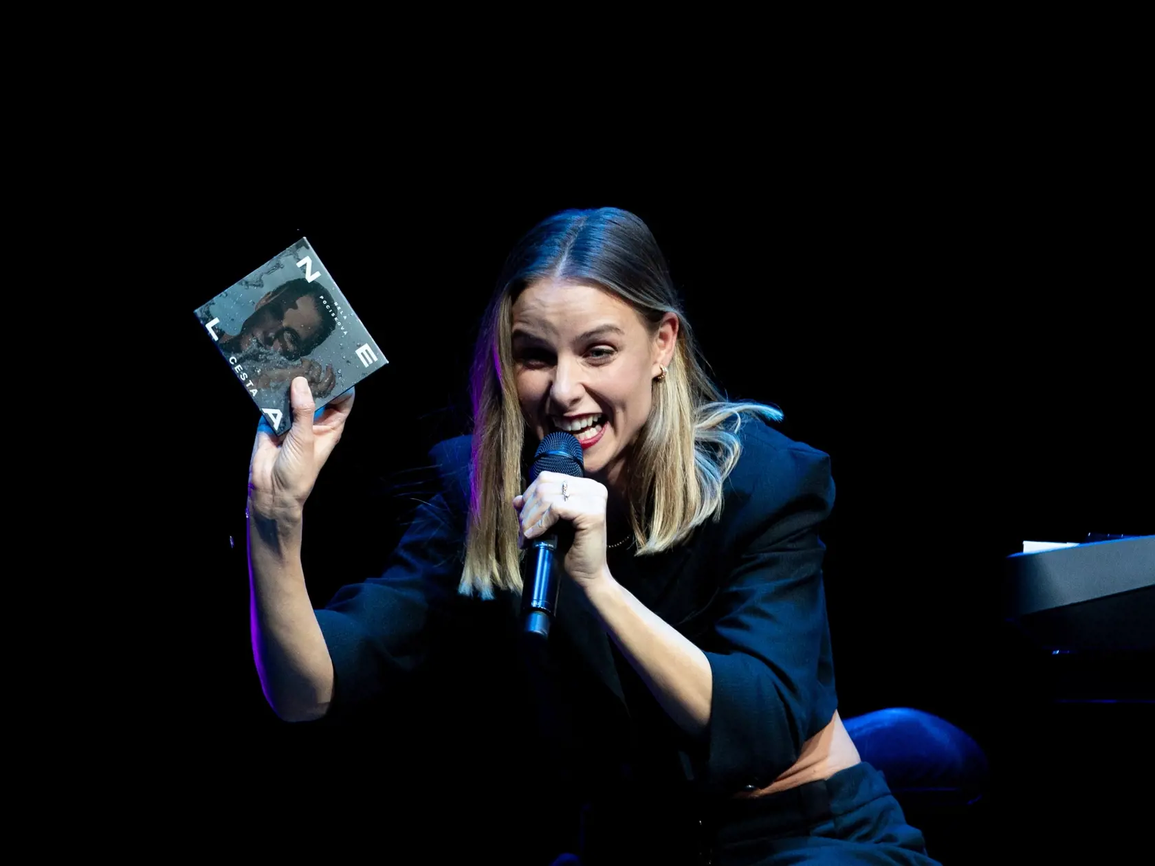 Nela drží v ruke svoj nový album Cesta. 