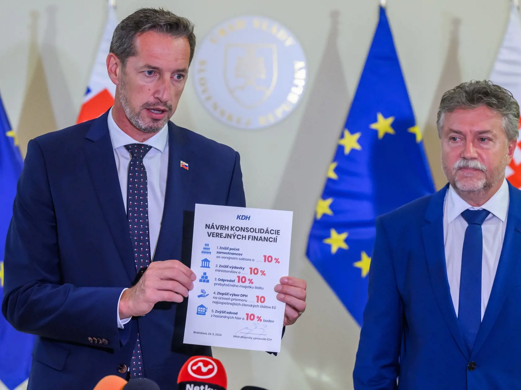 Na snímke zľava predseda opozičného Kresťanskodemokratického hnutia (KDH) Milan Majerský, ktorý ukazuje návrh konsolidácie verejnej financií z dielne KDH a člen predsedníctva KDH a ekonomický expert Jozef Hajko, sa účastnia na tlačovej konferencii po rokovaní premiéra Roberta Fica (Smer-SD) s predsedami opozičných strán a predstaviteľmi Ministerstva financií SR o konsolidácii na Úrade vlády SR v Bratislave v utorok 24. septembra 2024. Opozičné strany KDH a Progresívne Slovensko (PS) pozvanie pre