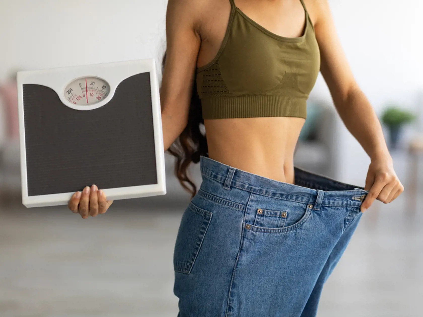 Unrecognizable,Indian,Woman,In,Oversized,Jeans,Holding,Scales,,Showing,Results
