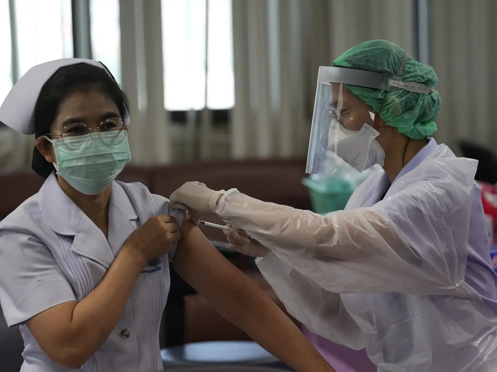 JB 27 Bangkok - Thajská zdravotníčka (vľavo) dostáva vakcínu Pfizer-BioNTech počas očkovania zdravotníkov proti ochoreniu COVID-19 vo vakcinačnom centre nemocnice v Bangkoku 10. augusta 2021. FOTO TASR/AP

A health worker receives a booster shot of the Pfizer-BioNTech COVID-19 vaccine at Bangkok Metropolitan Administration General hospital in Bangkok, Thailand, Tuesday, Aug. 10, 2021. (AP Photo/Sakchai Lalit)
