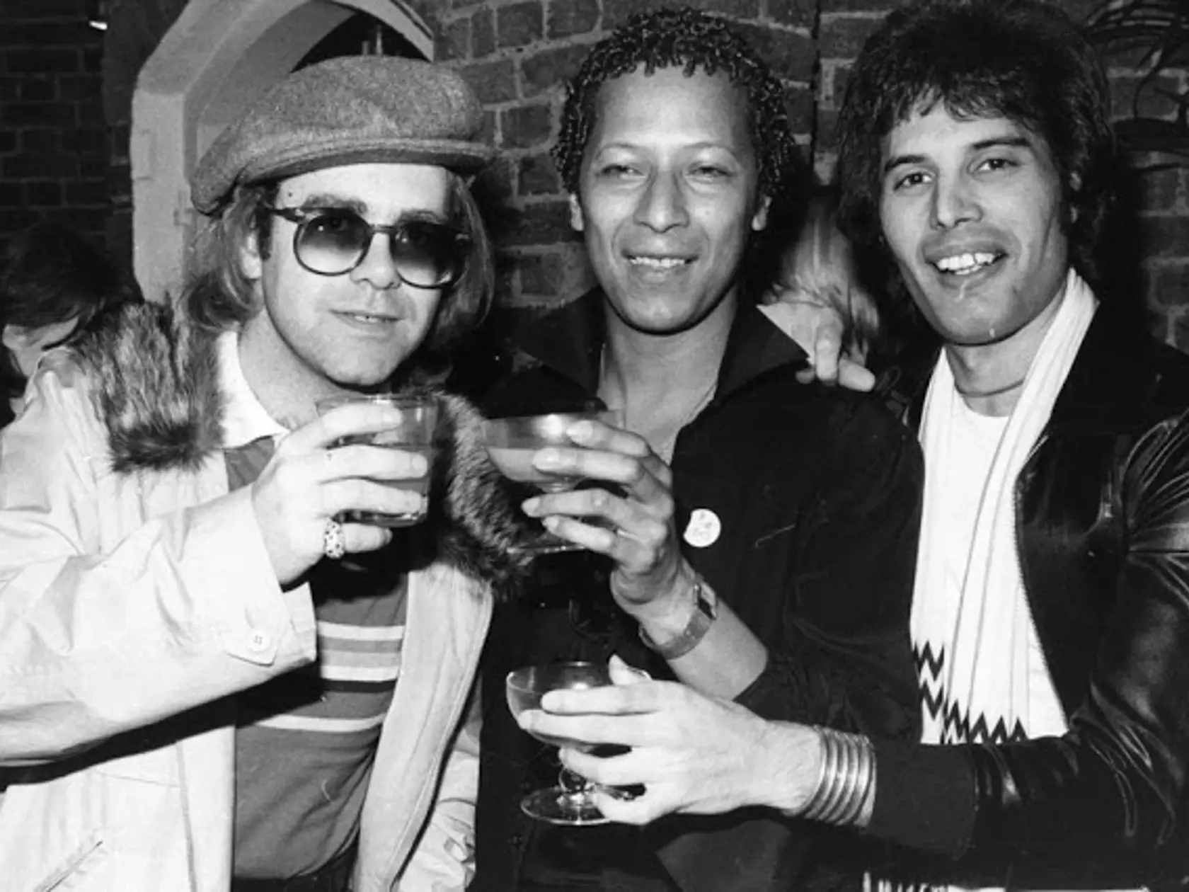 Spevák Queen Freddie Mercury a spevák Elton John, vľavo a Peter Straker, v strede, tiež spevák.
