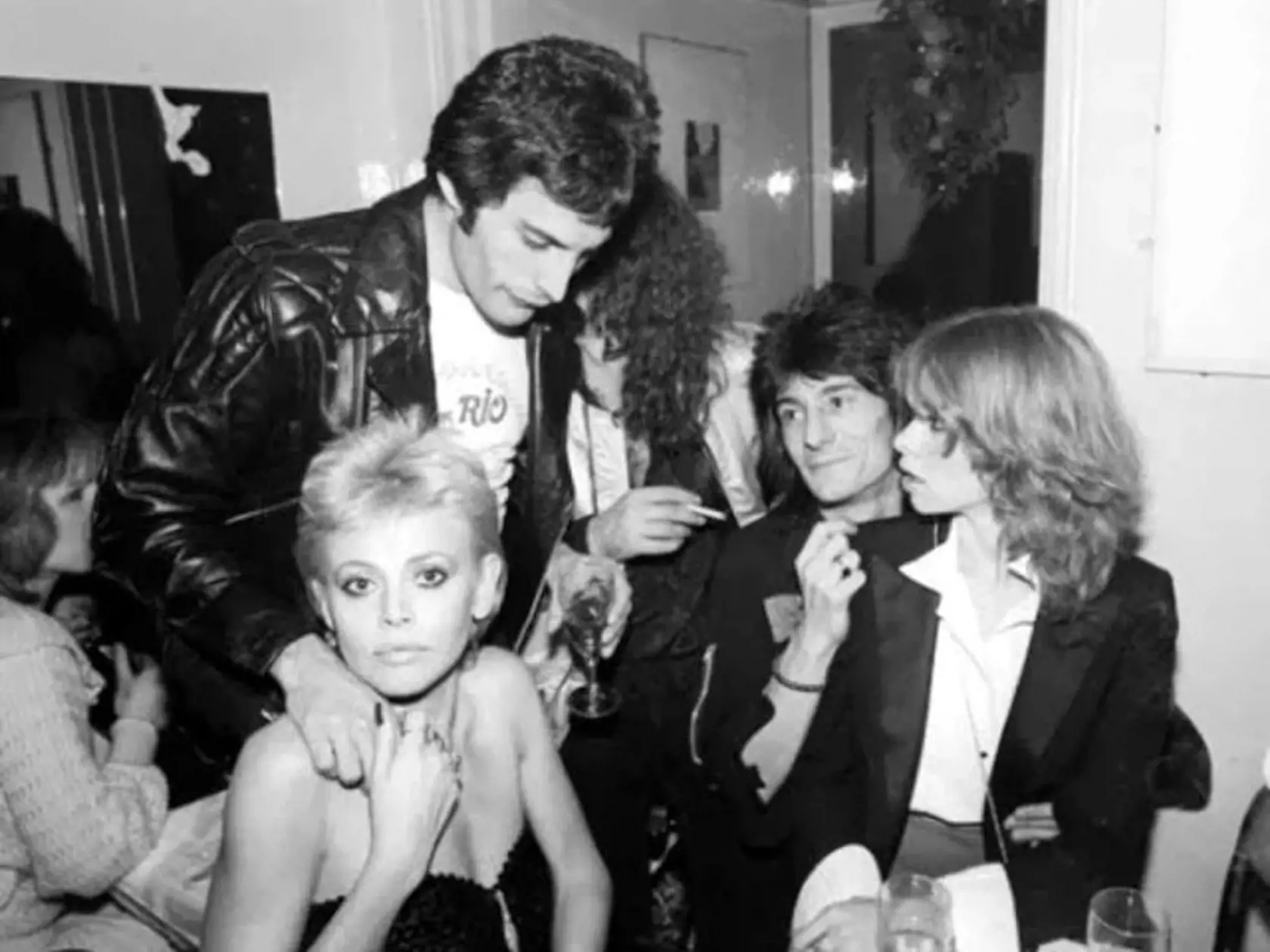 Spevák Queen Freddie Mercury a herečka Britt Ekland, a vedľa nich gitarista The Rolling Stones Ronnie Wood s druhou manželkou Jo, vpravo.
