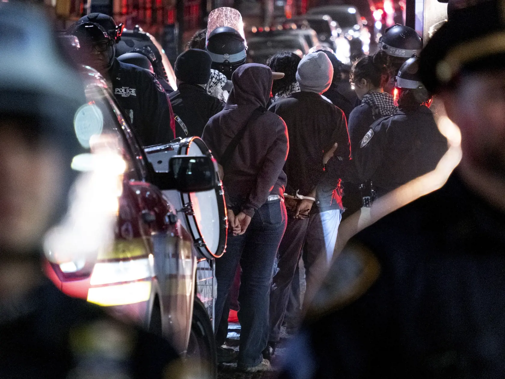 WA 11 New York - Na snímke osoby, ktoré  zadržala polícia v blízkosti kampusu Kolumbijskej univerzity v New Yorku v utorok 30. apríla 2024.  Newyorská polícia vyviedla demonštrantov z budovy Kolumbijskej univerzity, kde sa predtým zabarikádovali desiatky propalestínskych študentov. Tí predošlú noc obsadili budovu Hamilton Hall.  Policajti konali na žiadosť školy a zadržali desiatky ľudí. FOTO TASR/AP 

New York City police officers take people into custody near the Columbia University campus in 