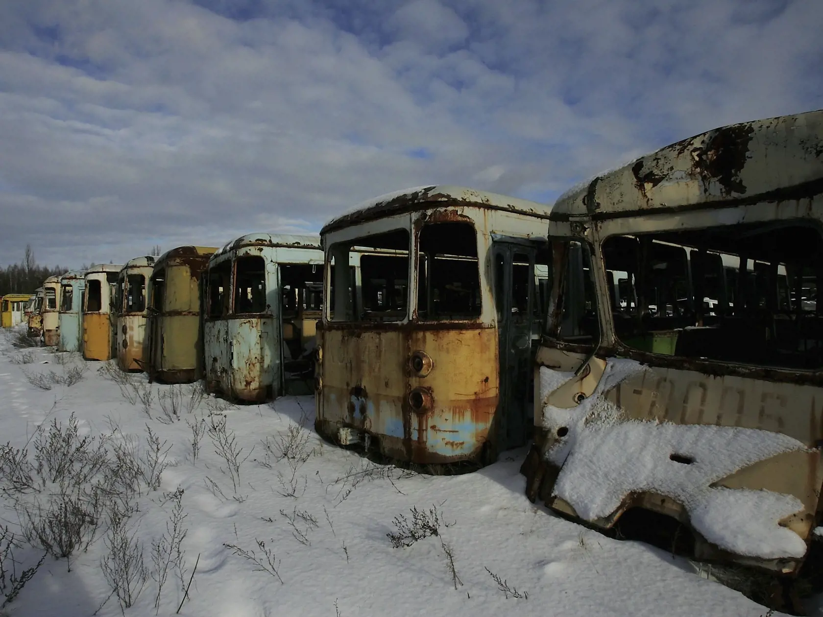 CHERNOBYL - JANUARY 31: Highly radiated buses used for transport during the 1986 catastrophe lay in a field near the village of Rosoha on January 31, 2006 in Chernobyl, Ukraine. From 27 April to 5 May, more than 30 military helicopters flew over the burning reactor. They failed to put out the fire with 2400 tonnes of lead and 1800 tonnes of sand. Tanks, helicopters, and all terrain vehicles from the Soviet Union's Red Army were left in this dump due to their high levels of radiation.  (Photo by 