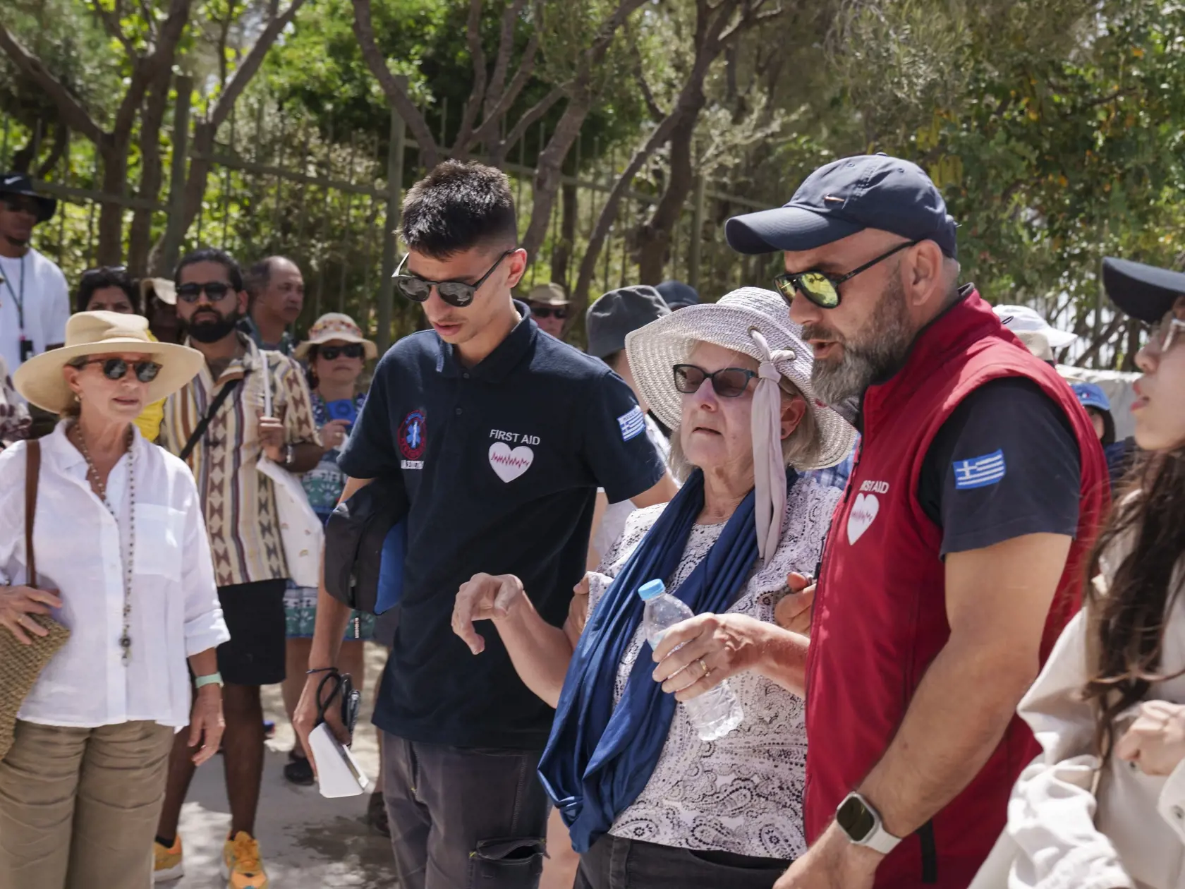 JB 28 Atémy - Záchranár vedie turistku spred starobylej Akropoly v centrálnych Aténach 12. júna 2024. Aténska Akropola, najnavštevovanejšie turistické miesto v Grécku, bude v stredu počas najväčších horúčav pre verejnosť zatvorená, oznámilo tamojšie ministerstvo kultúry. TASR o tom informuje podľa agentúry AFP. Akropola bude uzavretá od 12.00 do 17.00 h miestneho času. V stredu a vo štvrtok počas prvej tohtoročnej vlny horúčav očakávajú v Aténach teplotu až 43 stupňov Celzia, spresnilo ministers
