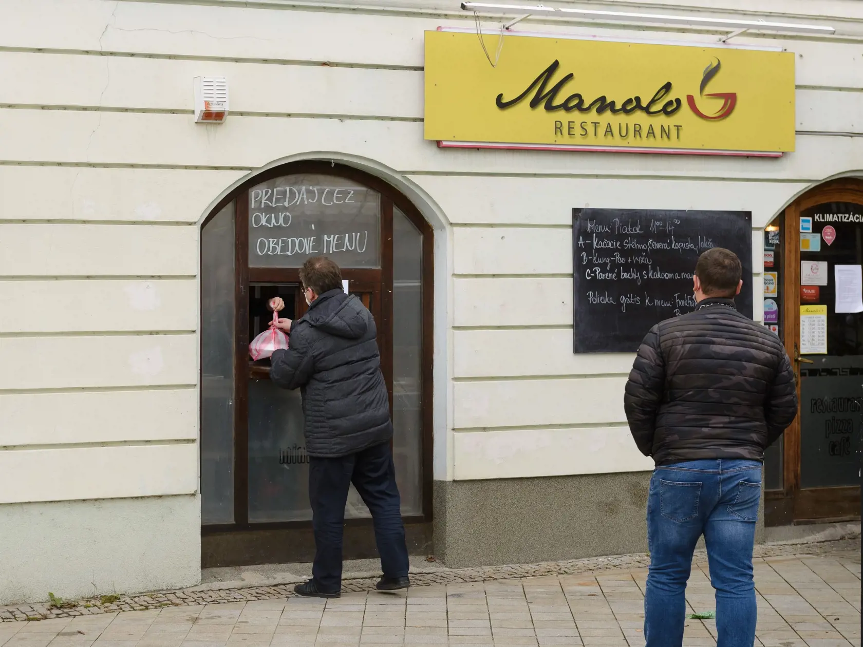 Fungovanie terás v kaviarňach a reštauráciách je od piatka 11. decembra 2020 zakázané. Naďalej môžu ponúkať donáškové služby alebo osobný odber. Zmeny priniesla vyhláška Úradu verejného zdravotníctva (ÚVZ) SR, ktorá reaguje na závery ústredného krízového štábu. Na snímke výdaj obedov v centre mesta Nitra 11. decembra 2020. FOTO TASR - Henrich Mišovič