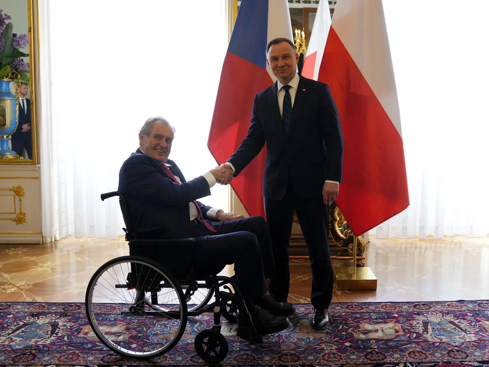 Na snímke zľava český prezident Miloš Zeman a poľský prezident Andrzej Duda si podávajú ruky počas stretnutia v Prahe 27. apríla 2022.