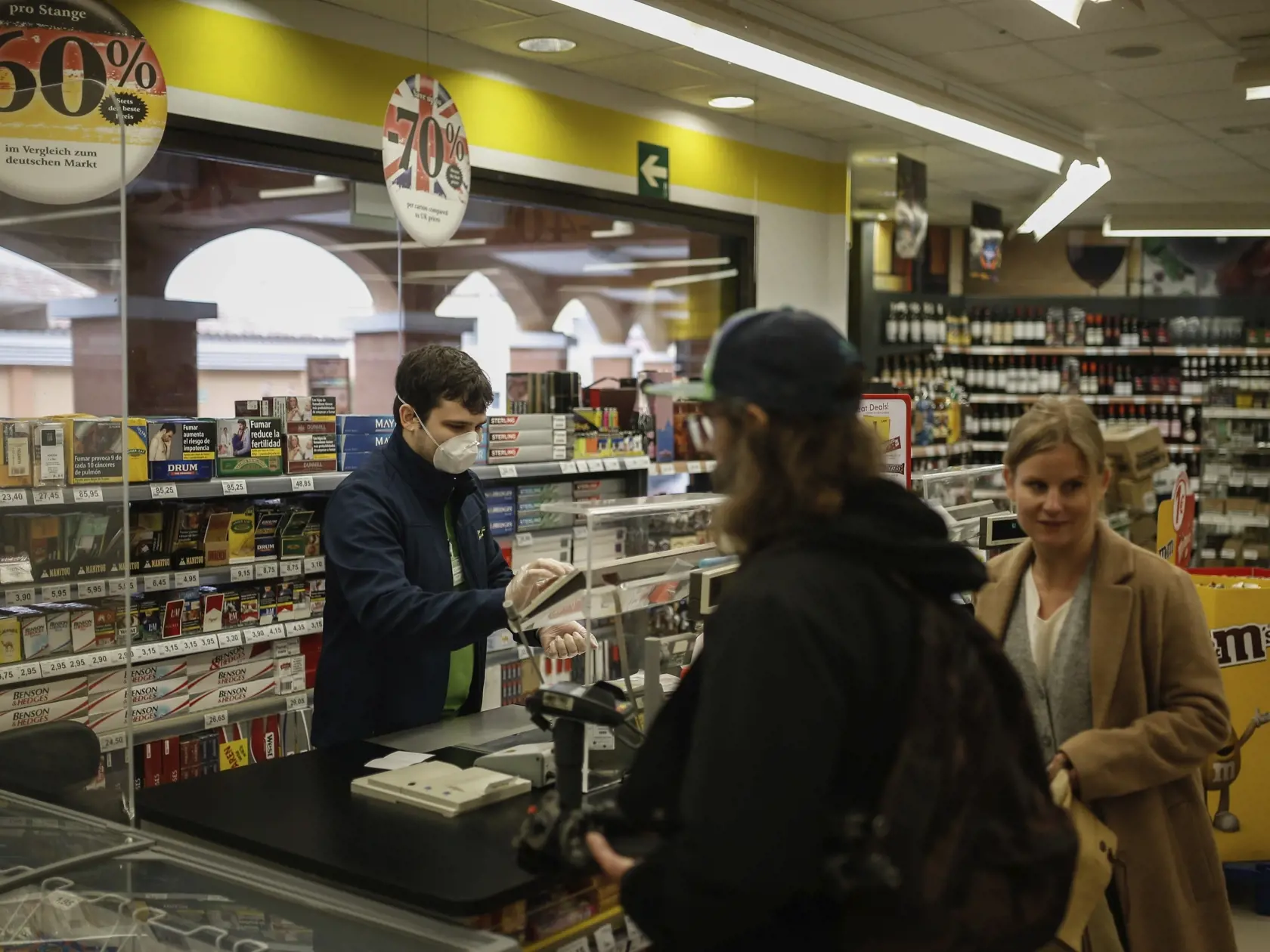 Predavač s ochranným rúškom na tvári predáva v miestnom supermarkete v La Calete na  španielskom ostrove Tenerife vo štvrtok 27. februára 2020.