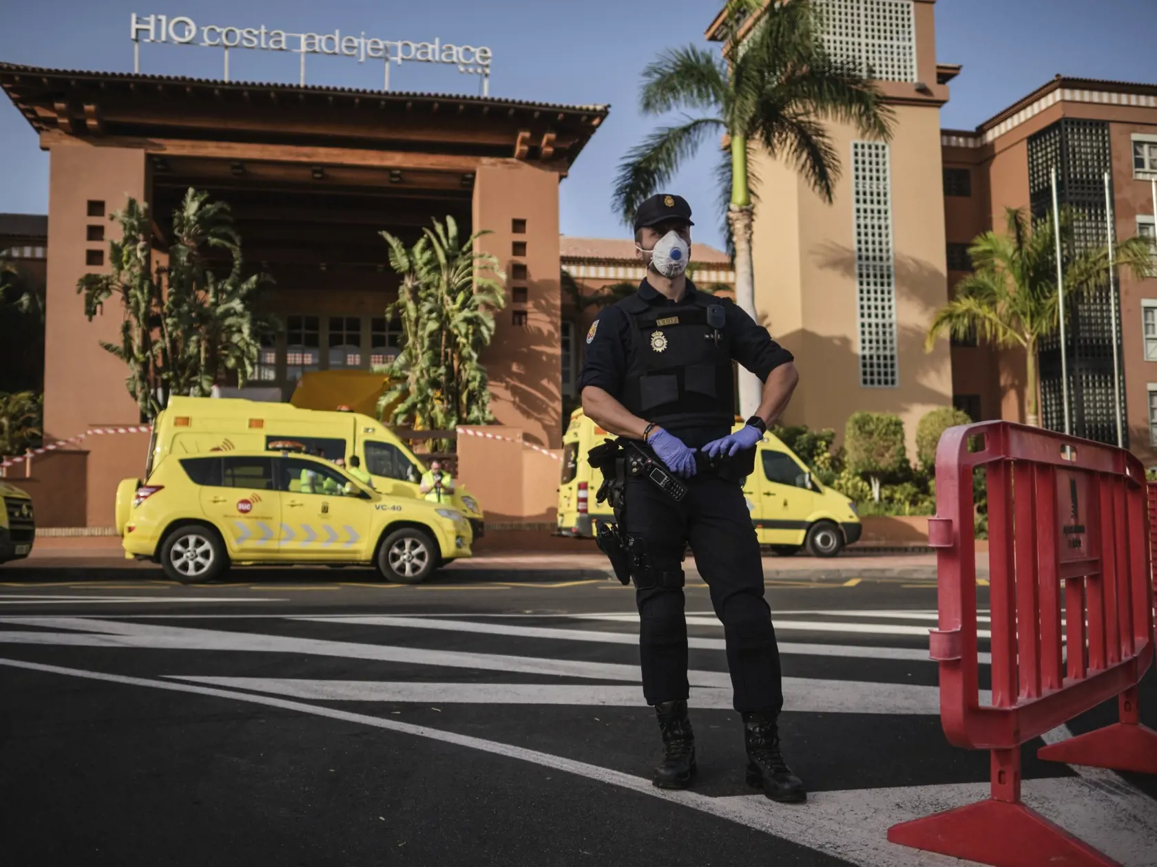 - Na snímke policajti s ochrannými rúškami stoja pred hotelom H10 Costa Adeje Palace v meste La Caleta, na španielskom ostrove Tenerife 26. februára 2020.