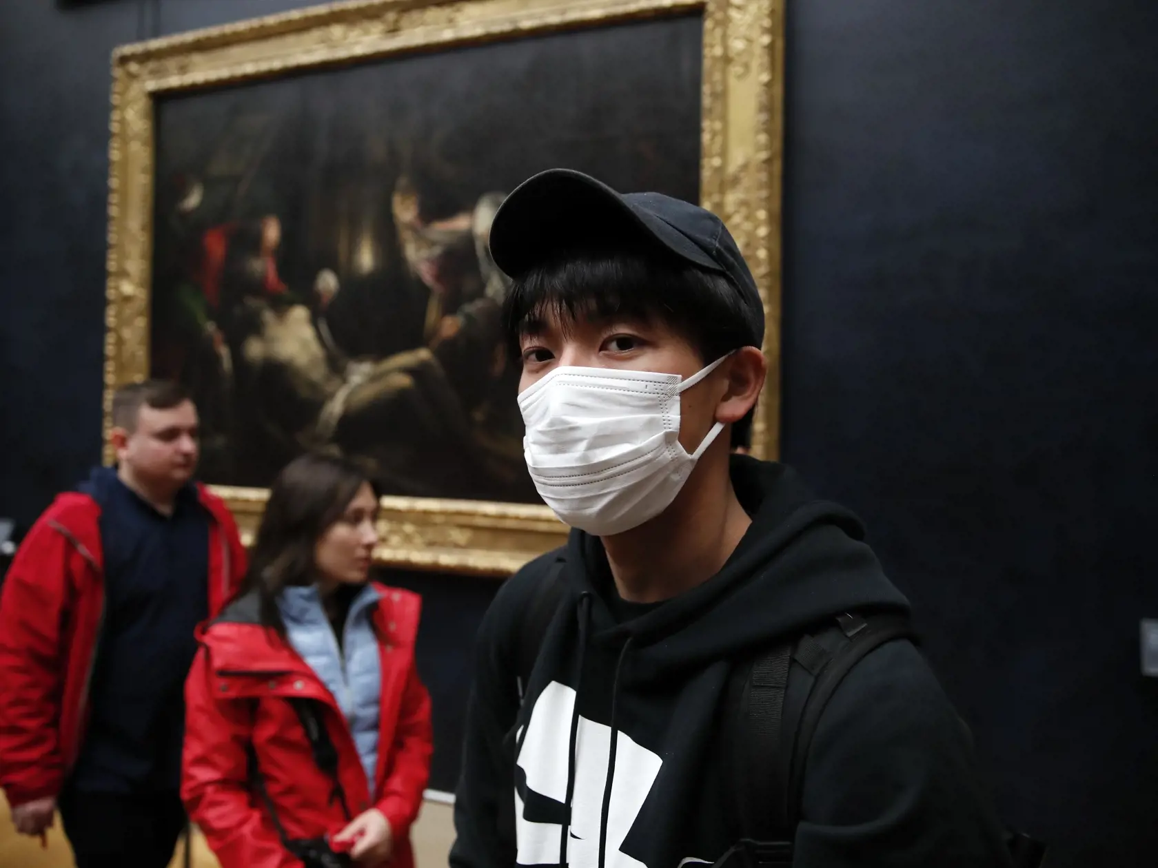 Turisti s ochrannými rúškami v múzeu Louvre v Paríži 5. marca 2020.